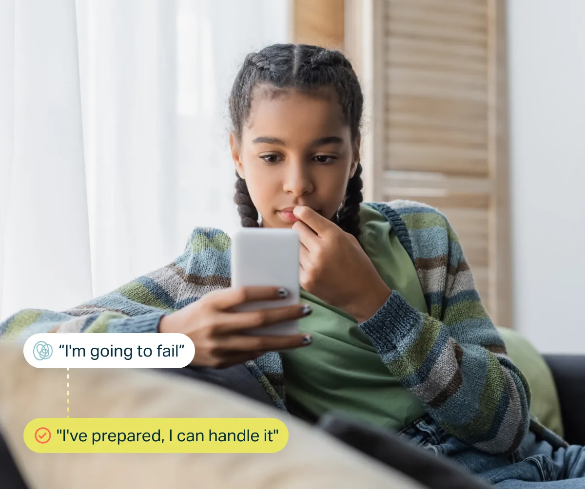 Young girl studies a smartphone with a worried expression; thought bubbles read “I’m going to fail” and “I’ve prepared, I can handle it.”