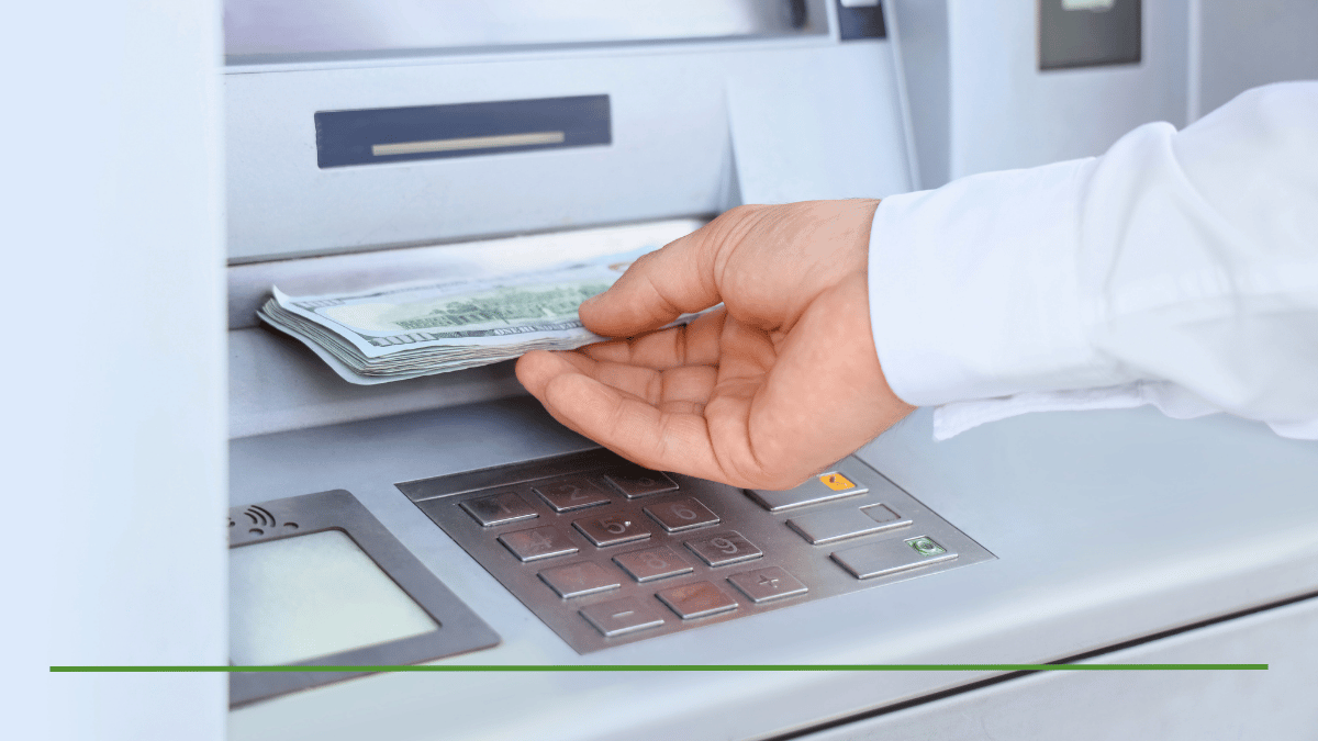Person withdrawing cash from an ATM, representing an IRA withdrawal above the required minimum distribution (RMD)