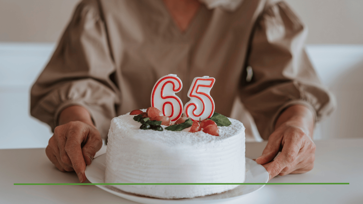 Woman celebrating her 65th birthday with a white frosted cake topped with number 65 candles, representing the age when many retirees ask about IRA taxes