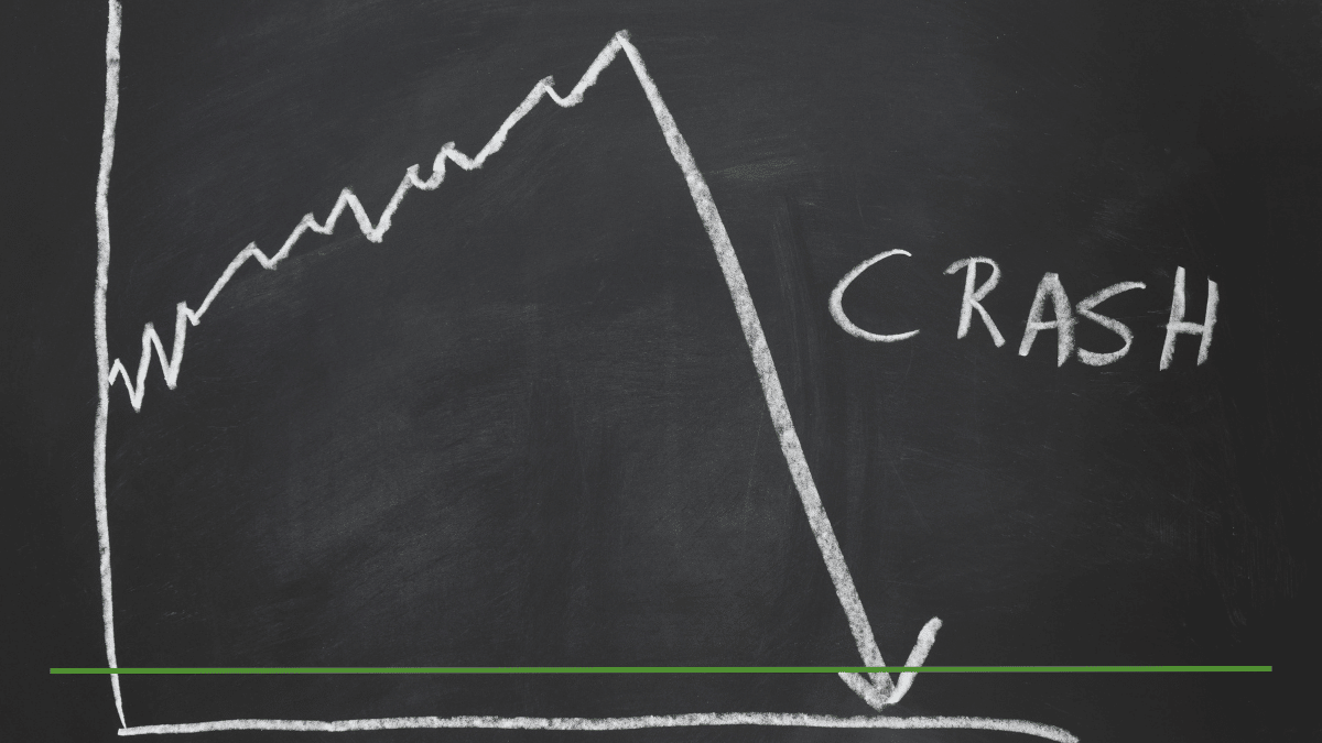 Chalkboard drawing of a stock market chart rising then sharply crashing downward, illustrating a market downturn and its effect on retirement accounts like an IRA.