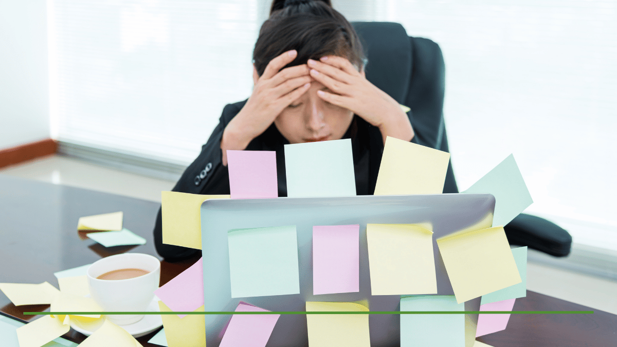 Stressed professional overwhelmed by sticky notes and paperwork at desk, representing the confusion of managing too many individual retirement accounts