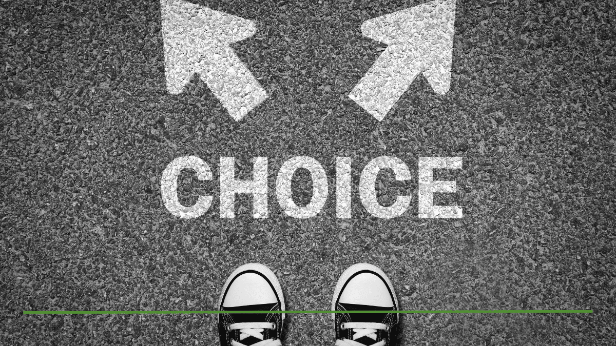 Person standing at a fork in the road with 'CHOICE' painted on the pavement and arrows pointing left and right, representing the decision between a 401(k) and a Roth IRA