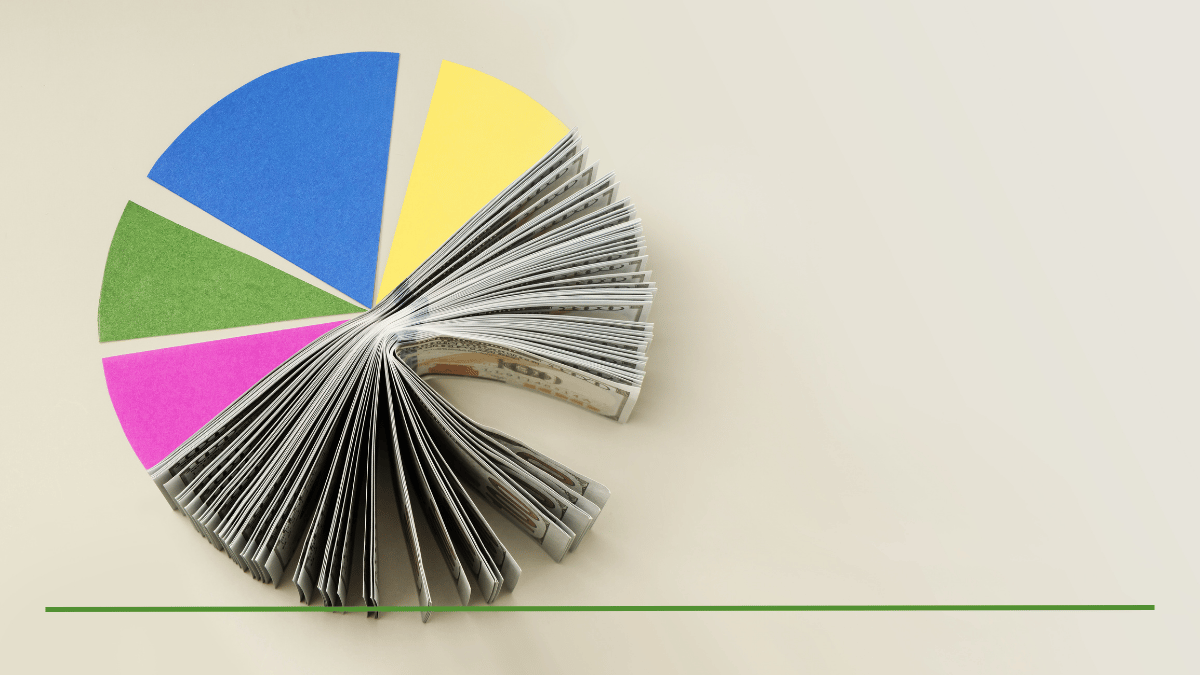 Pie chart made of colored paper wedges and fanned cash, representing portfolio rebalancing and asset allocation