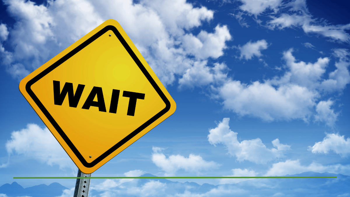 Yellow wait road sign against a blue sky, representing the importance of pausing before making a Roth conversion decision