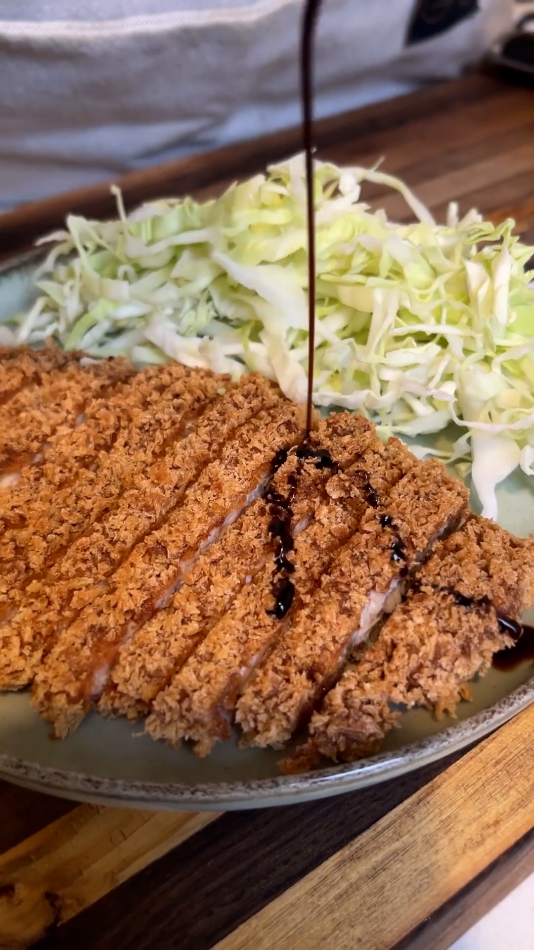 milanesa de cerdo tonkatsu japonesa servida con repollo blanco cortado fino y salsa tonkatsu
