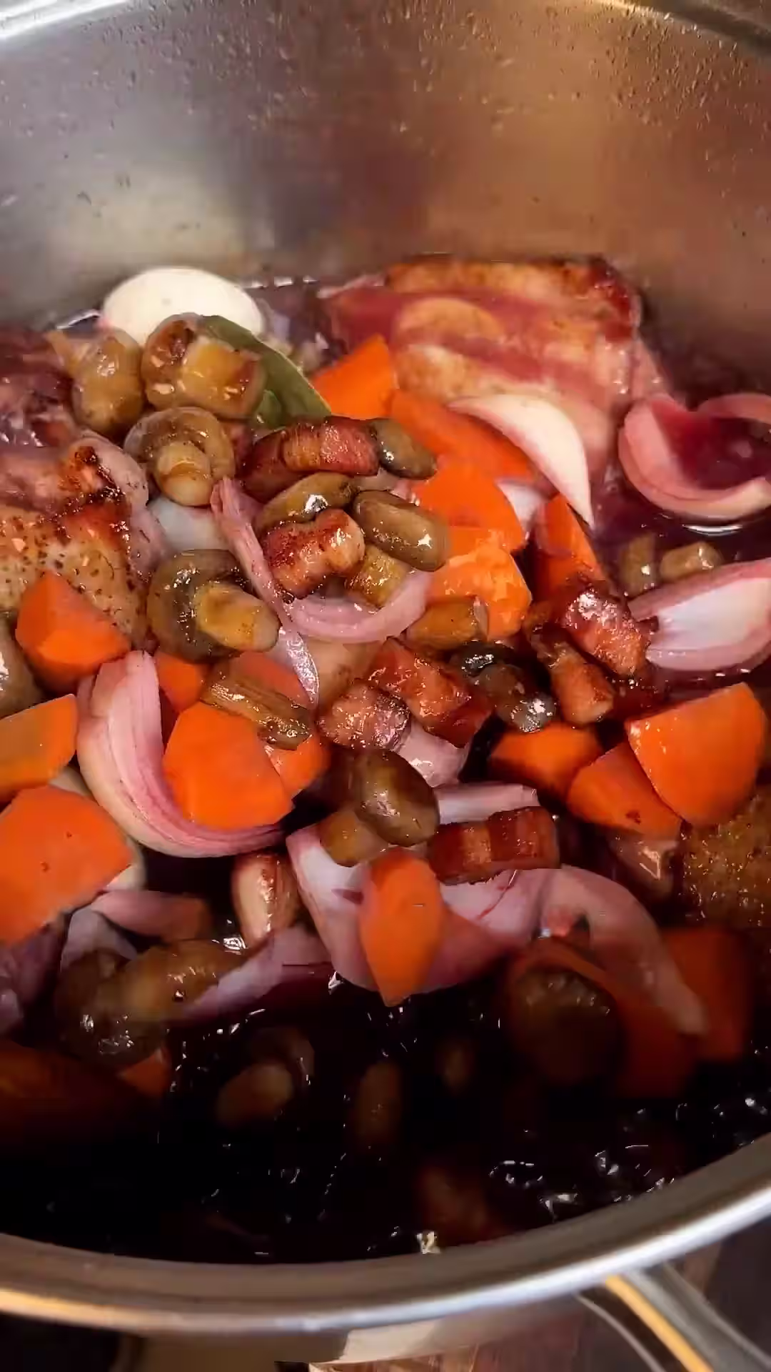 estofar el pollo junto con el vino de la marinada, la verdura, la panceta y los champiñones para el coq au vin