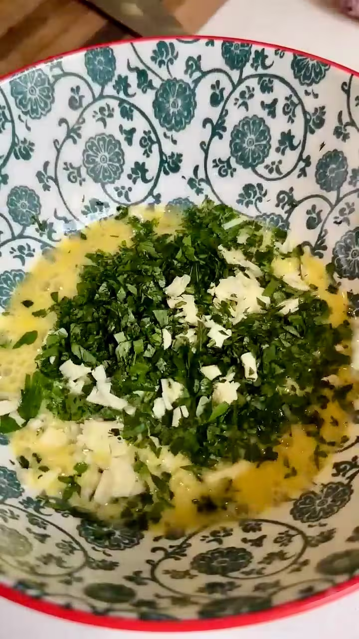 Huevo batido, perejil y ajo picado para hacer huevos tontos