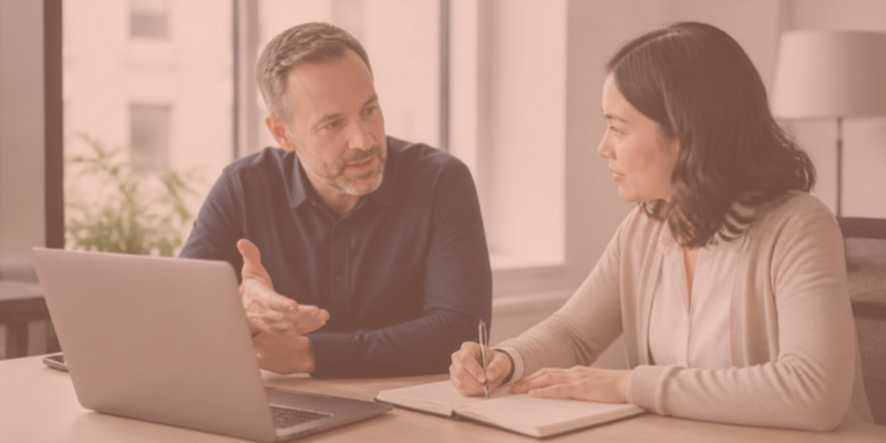 An expert trainer working one-on-one with a manager who is taking notes