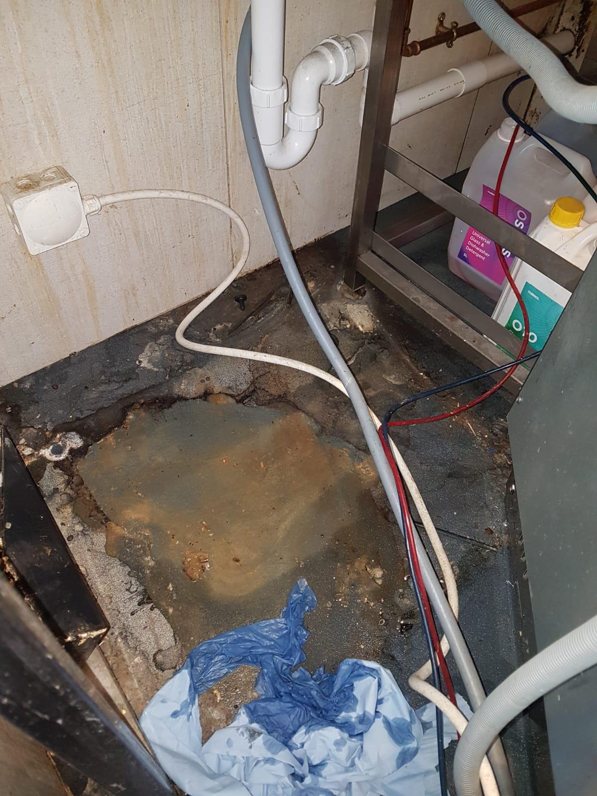 image of plumber working under a sink