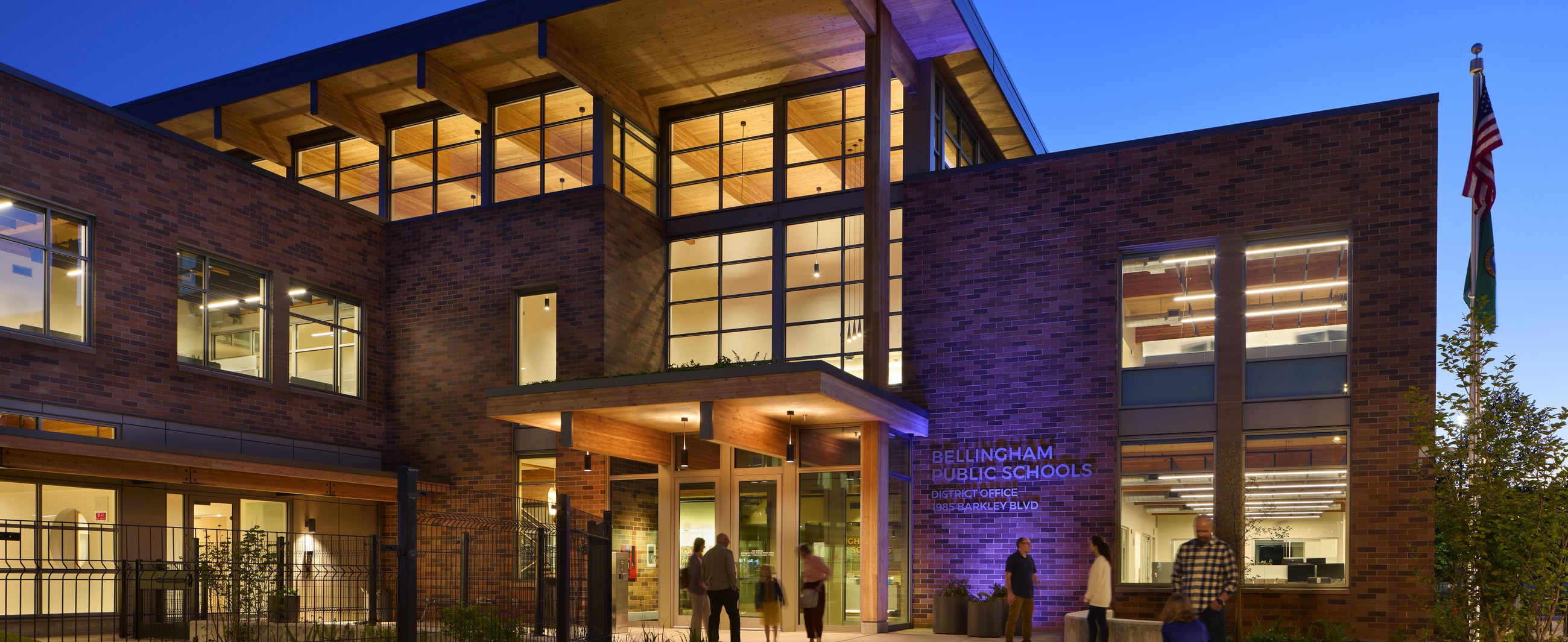 District Office Building illuminated entrance and atrium at twilight