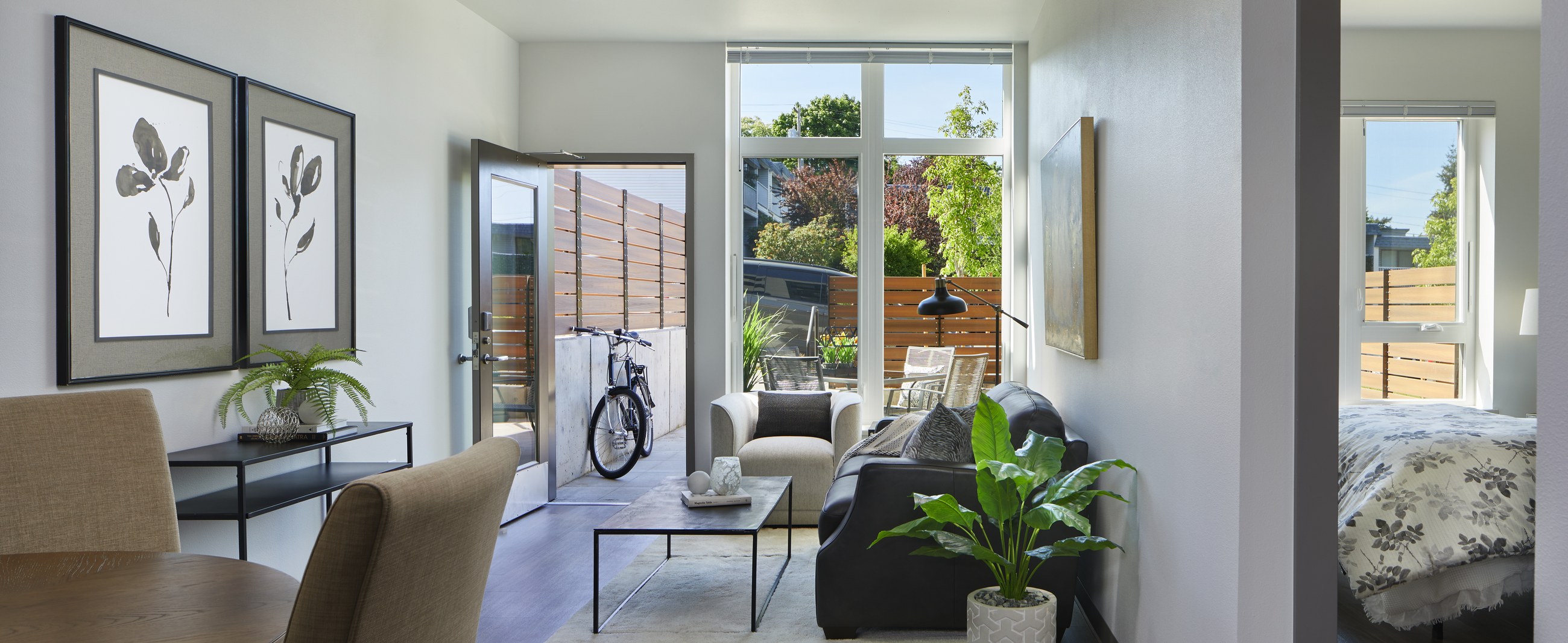 Bright Samish Commons interior living space with large windows and greenery