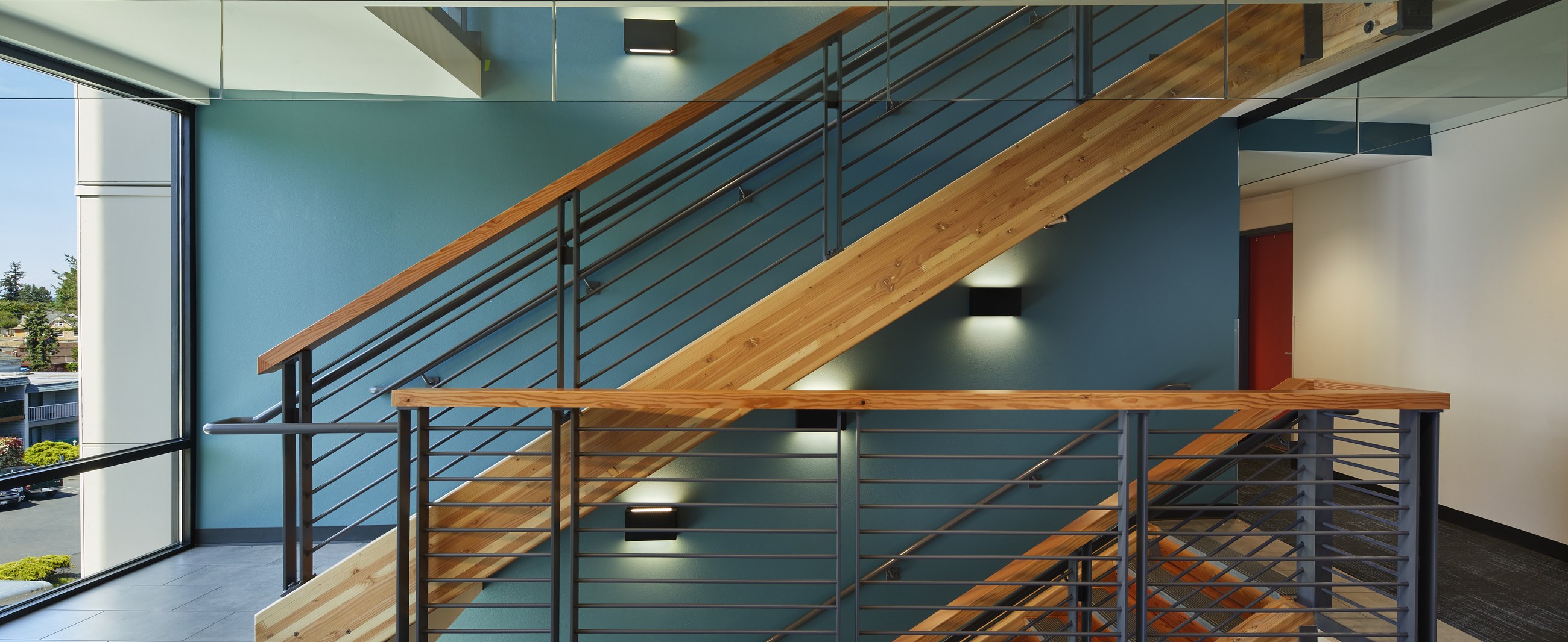 Samish Commons interior lobby with timber stair and teal accent wall