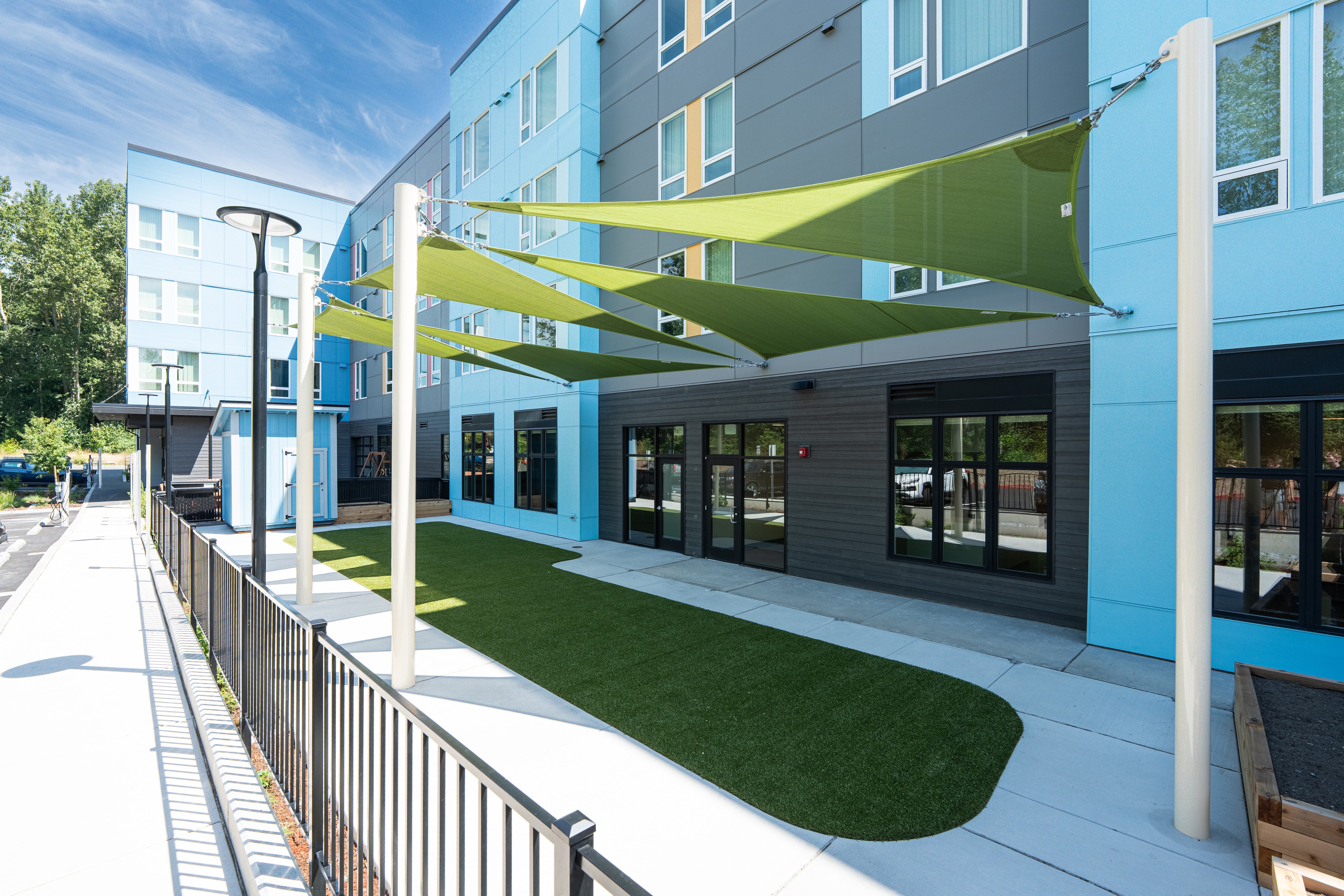 Courtyard with green shade sails at Bellis Fair Family Housing in Bellingham