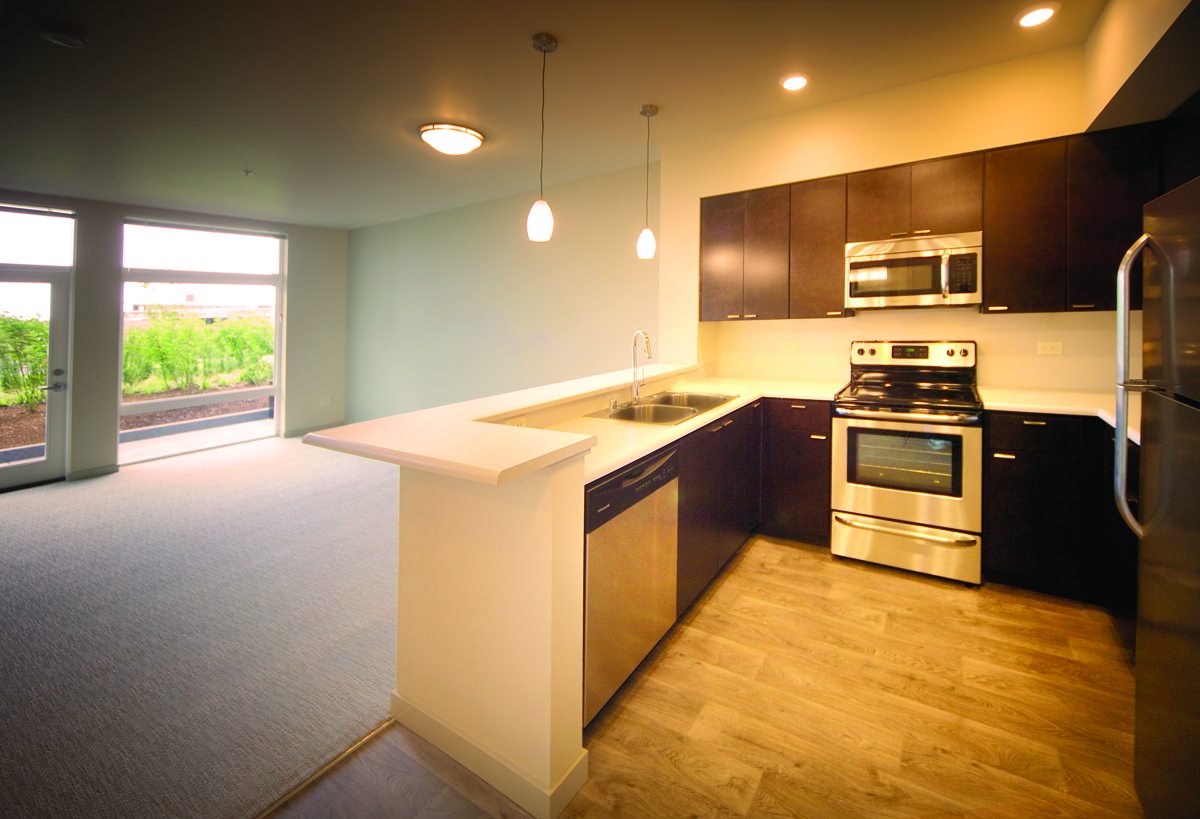 Finished apartment kitchen at The Cornerstone with espresso cabinets and stainless appliances