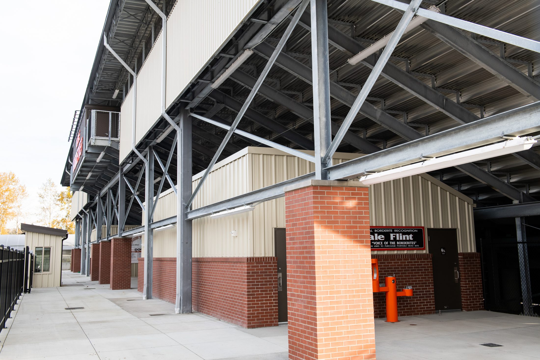 Concourse beneath the grandstands with brick support buildings and the Dale Flint memorial fountain