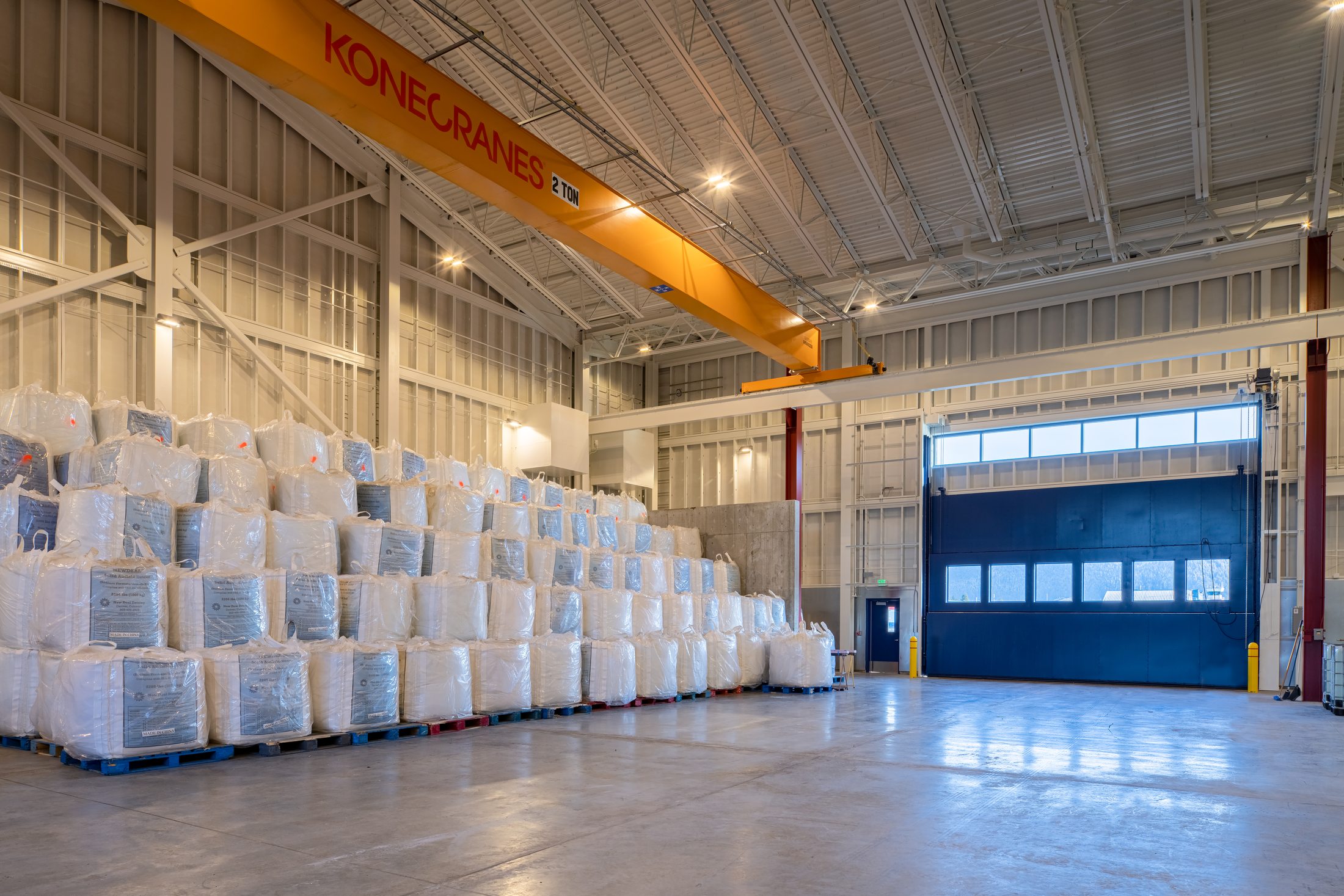 Palletized deicing bags stacked beneath the bridge crane inside the sand storage bay, Juneau International Airport