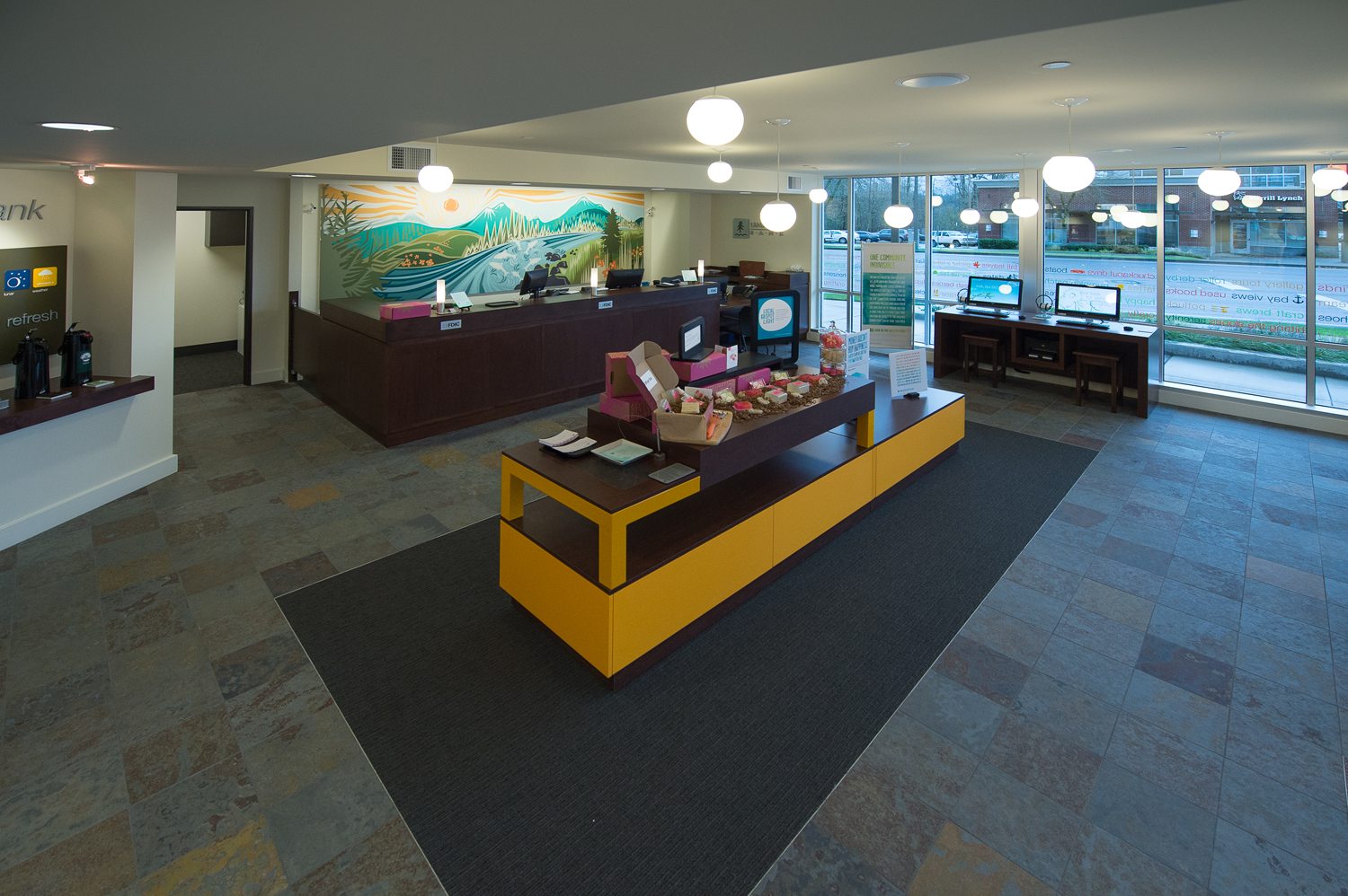 Open banking floor with retail-style island and Umpqua's signature mural, Bellingham branch