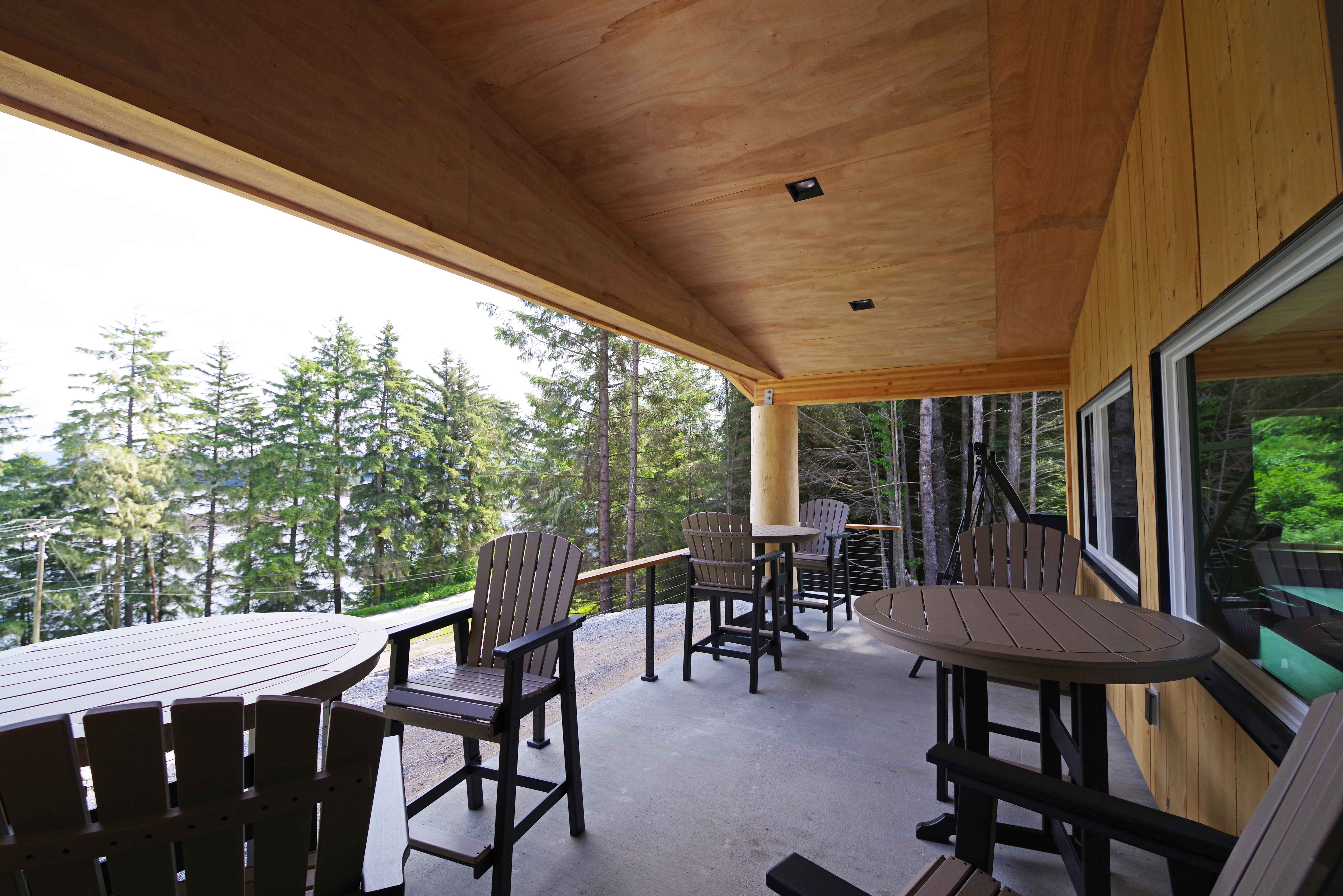 Covered porch with seating overlooking forest and water at the Angoon Visitor Center
