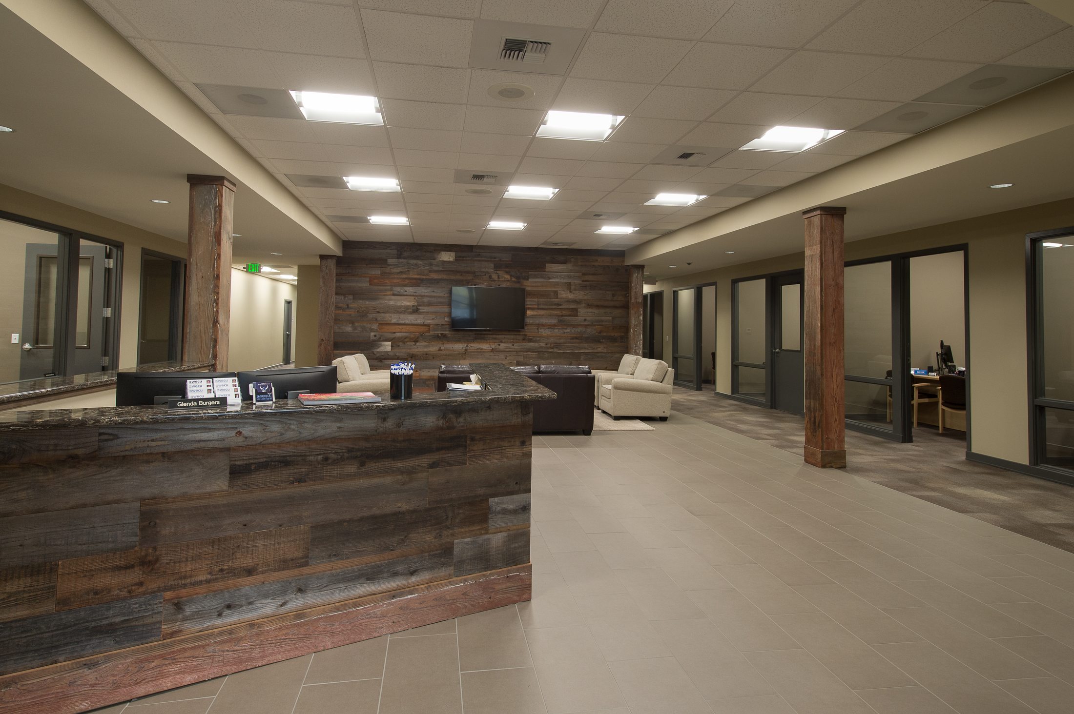 Reclaimed-wood reception desk and open banking hall at WECU's Barkley District branch