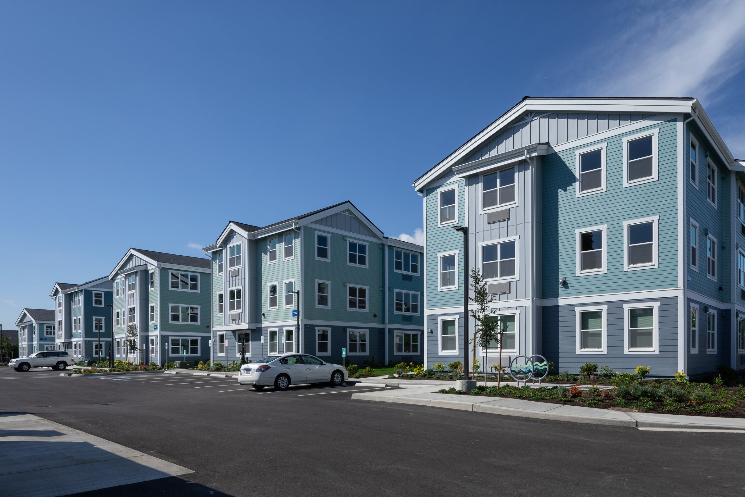Row of completed Ballington Flats apartment buildings along new parking and landscaping in Burlington, Washington