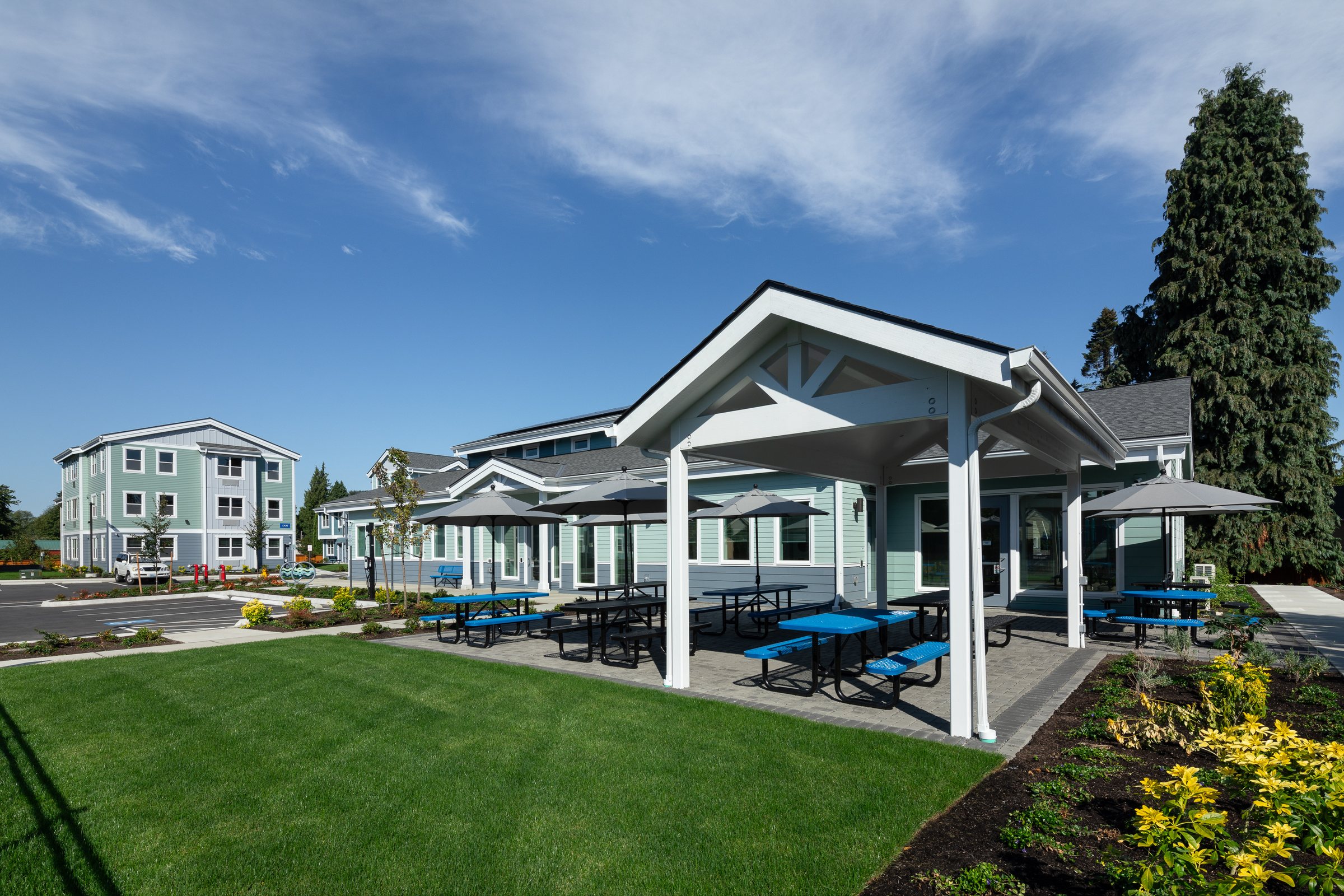 Covered picnic pavilion with blue tables outside the resident services building at Ballington Flats