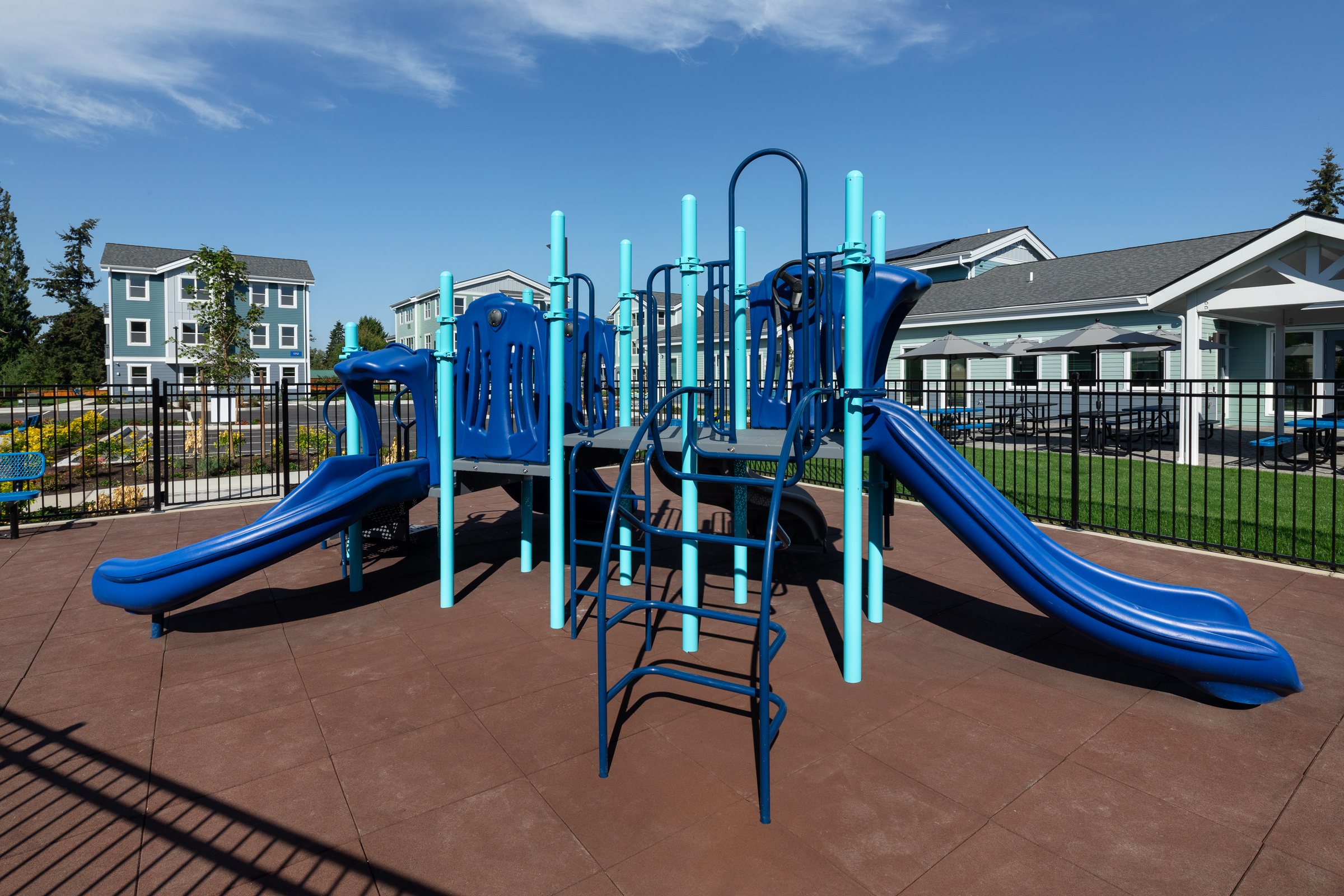 Fenced playground with blue slides at Ballington Flats
