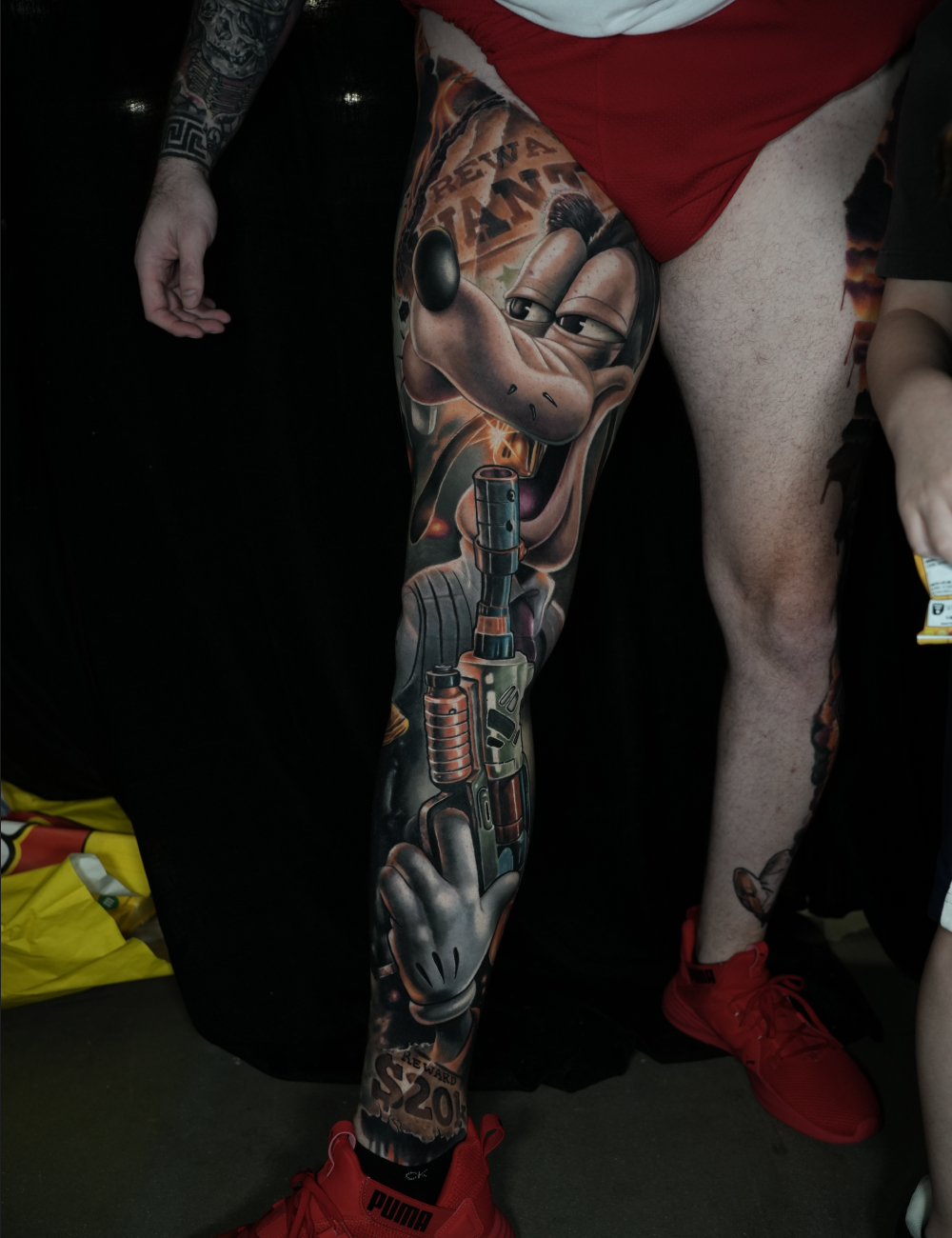 Color pop art leg sleeve tattoo of Goofy with a rifle and cartoon gloves by LuisK Osorio