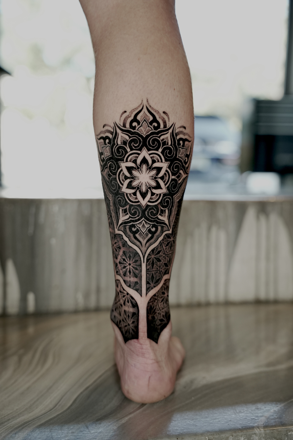 Geometric tattoo of a mandala with sacred geometry patterns on the calf at The Secret Tattoo Studio in Tampa