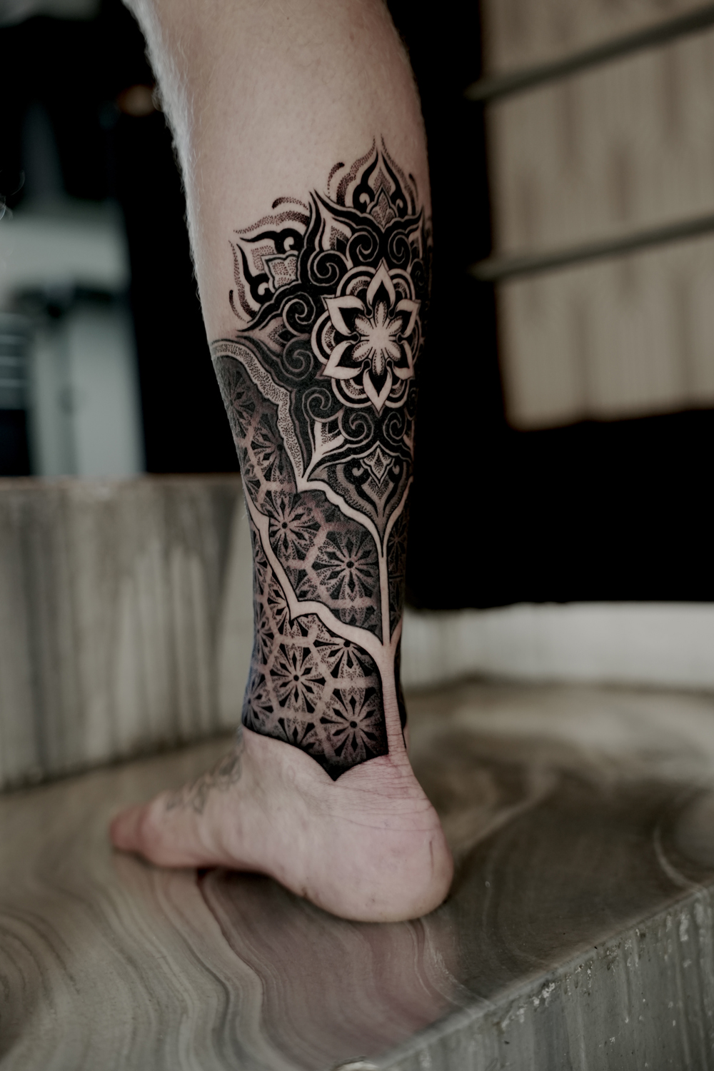 Geometric tattoo of a dotwork mandala with ornamental patterns on the calf at The Secret Tattoo Studio in Tampa
