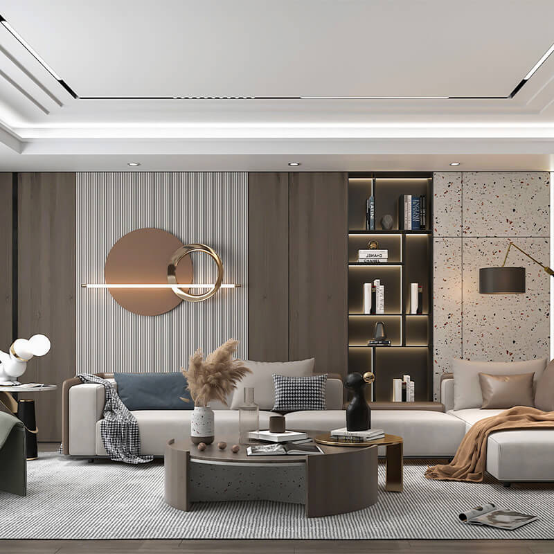 Modern living room with beige sectional sofa, decorative throw pillows and blankets, a circular sculptural wall light, a coffee table with vases and books, and a backlit shelving unit with books and decor.