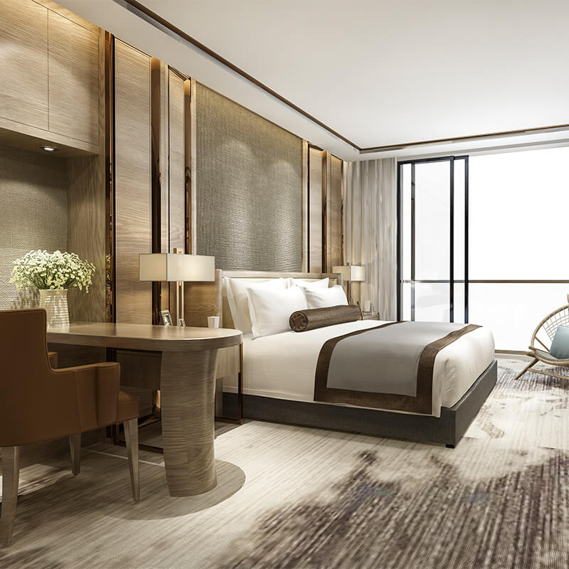 Modern hotel room with a large bed featuring white and brown linens, wooden desk with a chair and a vase of flowers, floor lamp, and a sliding glass door with curtains.