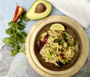 Ripe Shepard avocados, diced carrots, and aromatic spices laid out on a wooden bowl as a breakfast. 