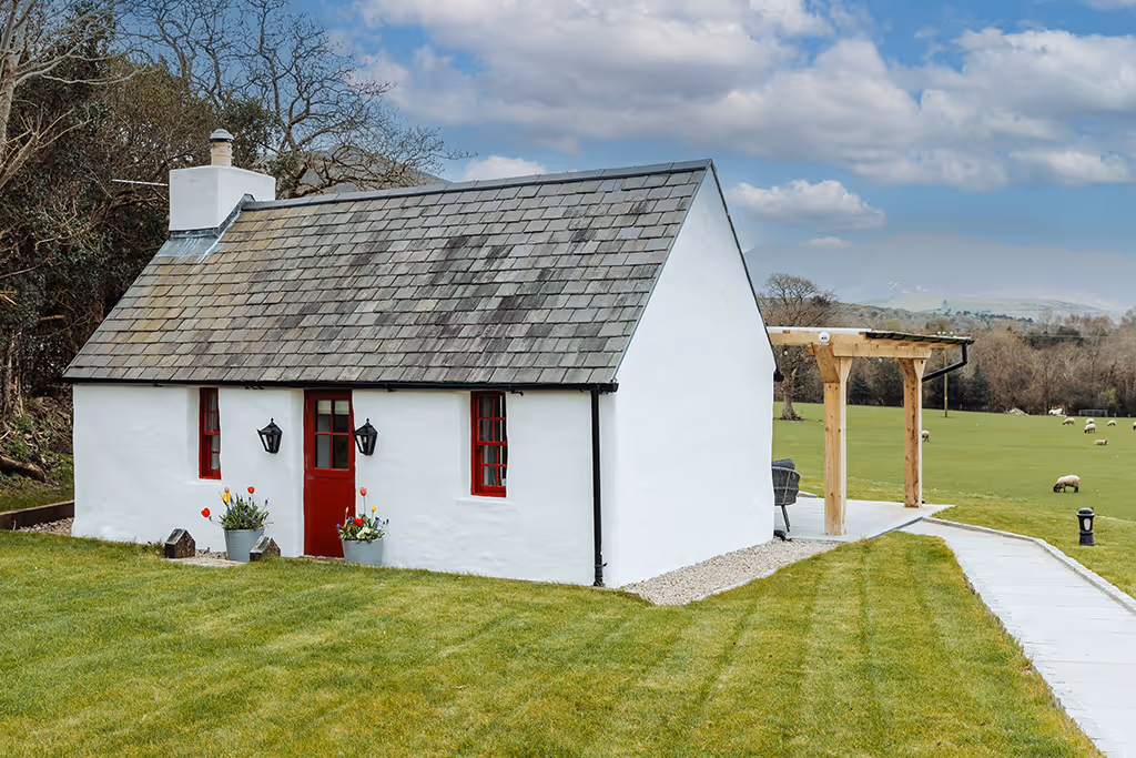 Outside picture of the Gap of Dunloe Cottage, with a sunset sky