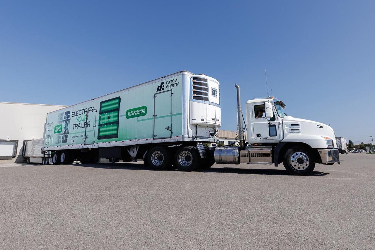 Range eTrailer refrigerated trailer with "Electrify Your Trailer" graphics hitched to a tractor