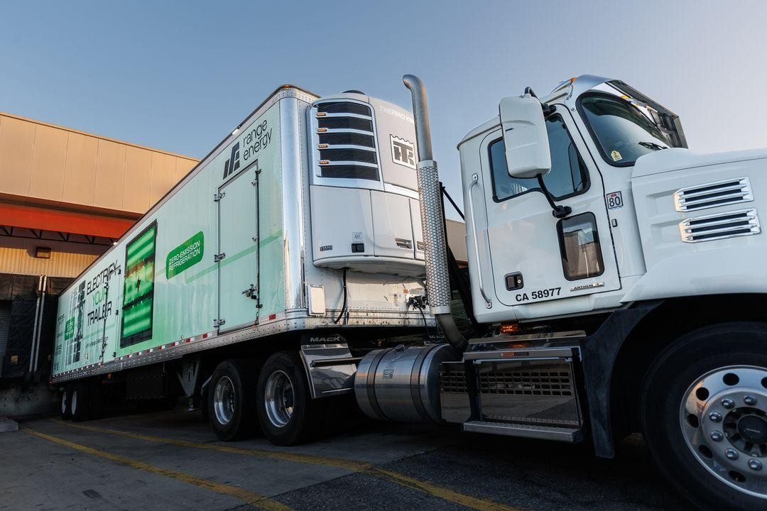 Range eTrailer with zero-emission refrigeration unit hitched to a diesel tractor at a loading dock
