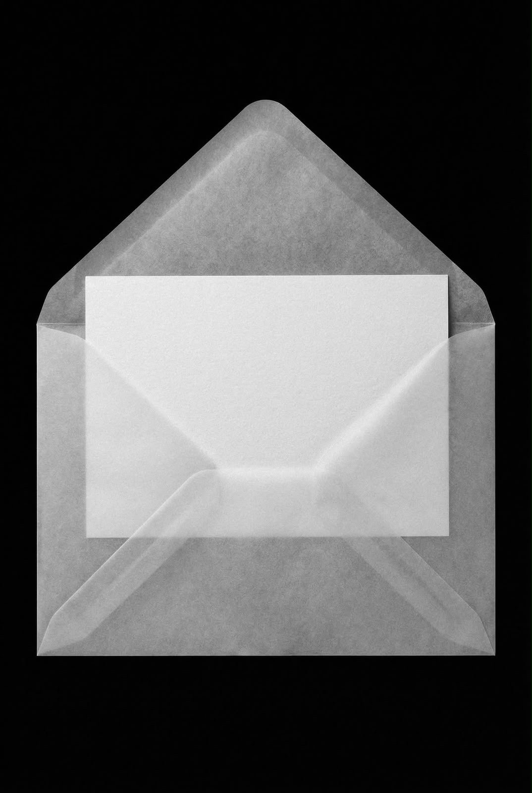 Translucent vellum envelope holding a white note card on a black background