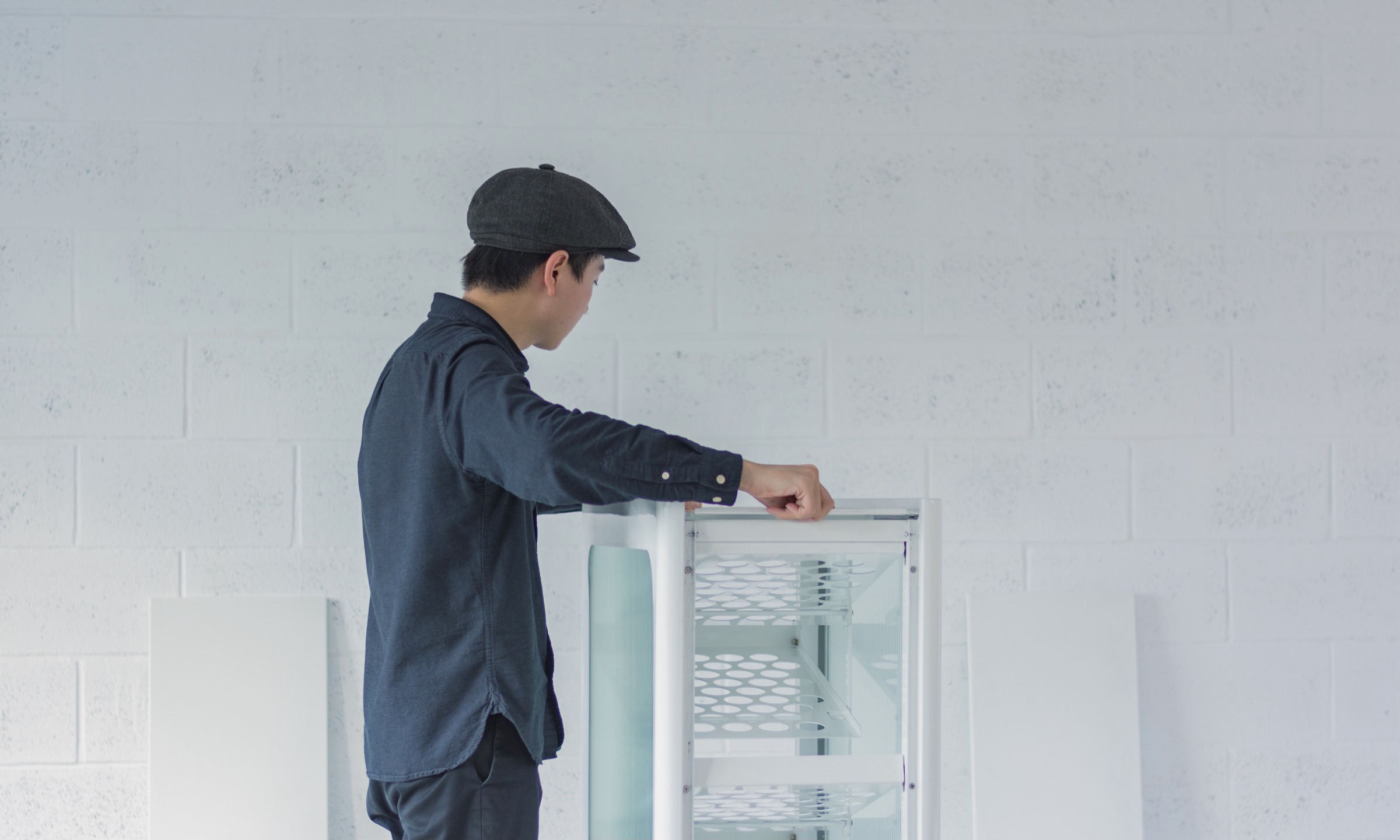 A designer opening the side door of the recycling bin