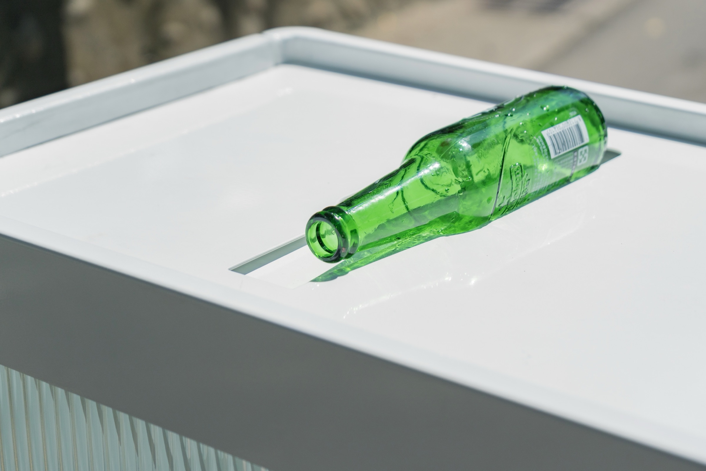 Close-up of a green bottle entering the insertion slot