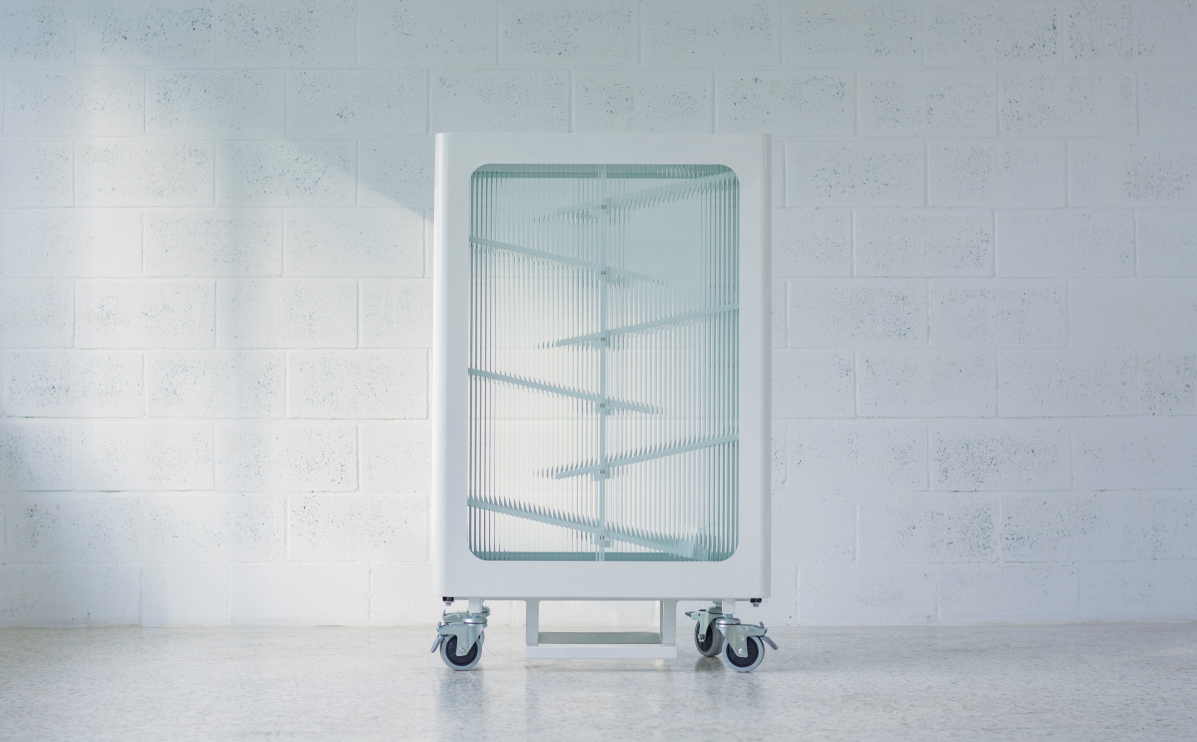 Front elevation of the recycling bin against a white brick wall