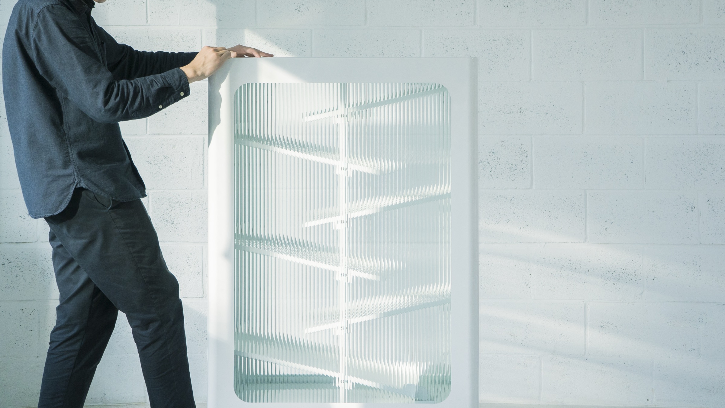 A designer handling a fluted glass panel