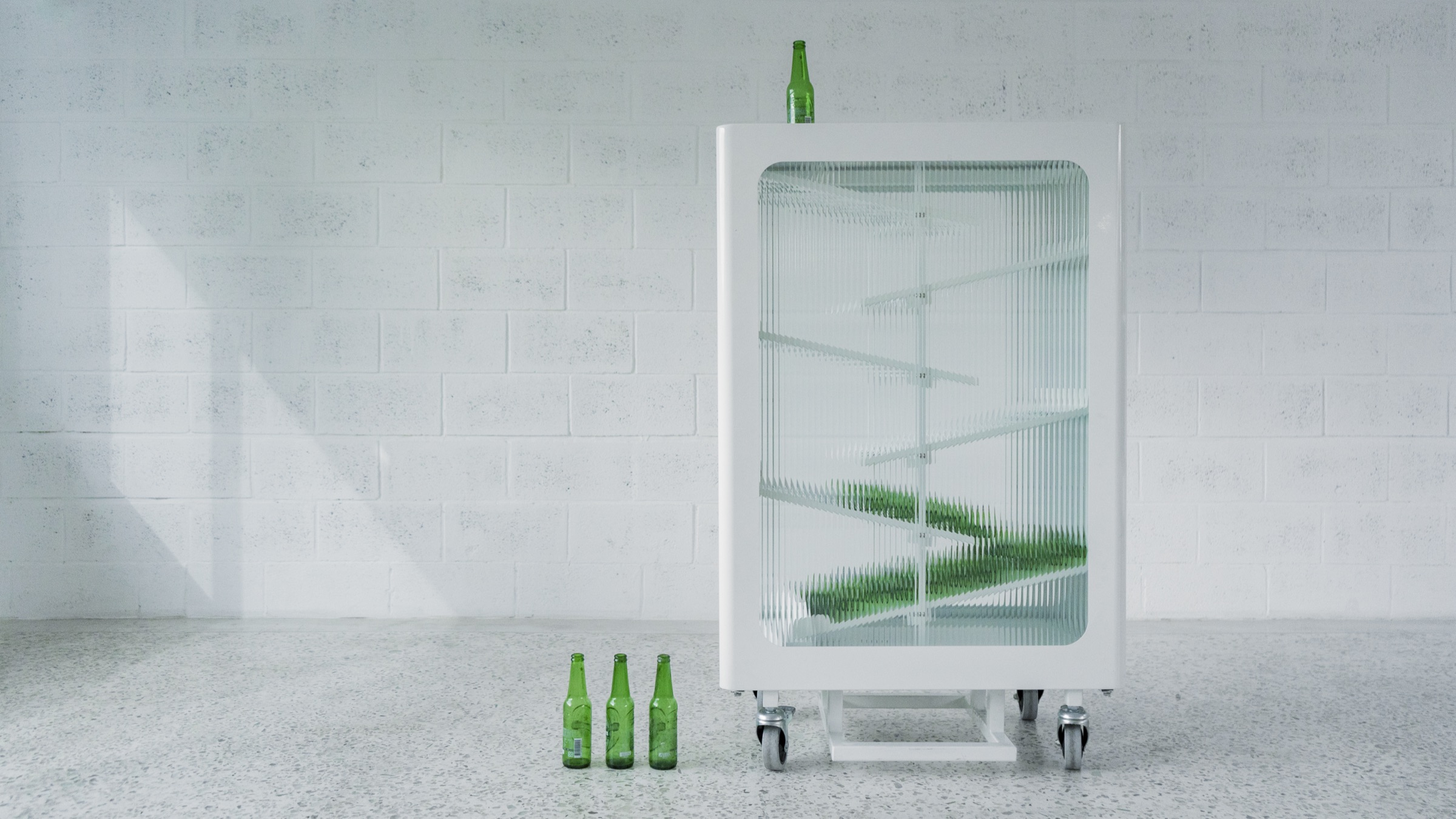 The recycling bin in a sunlit interior with bottles on the floor