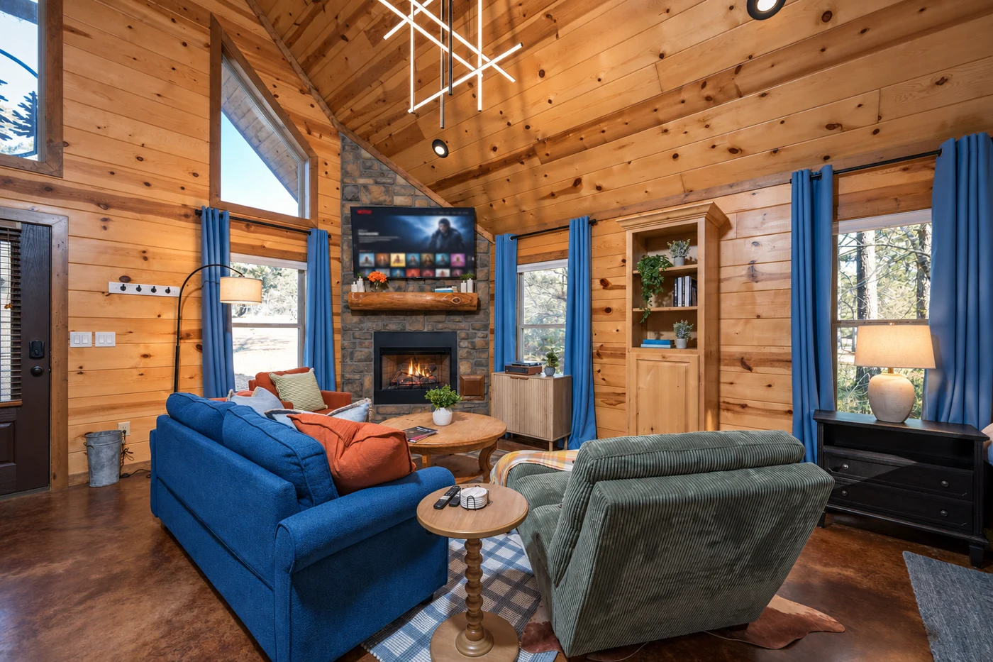 Blue sofa and green armchairs around the indoor fireplace at Hearth and Heritage