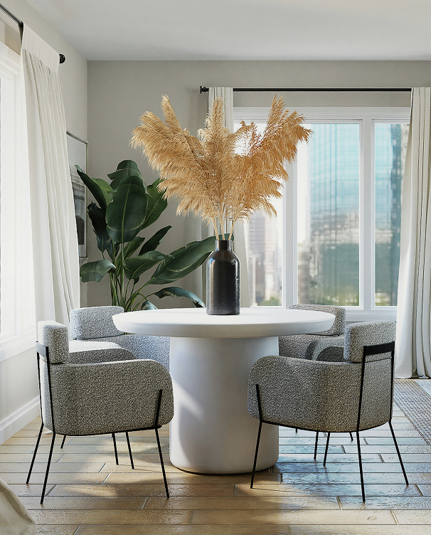 Three people collaborating in a cozy room with one person standing and smiling, another leaning over a table, and a third reading a document.