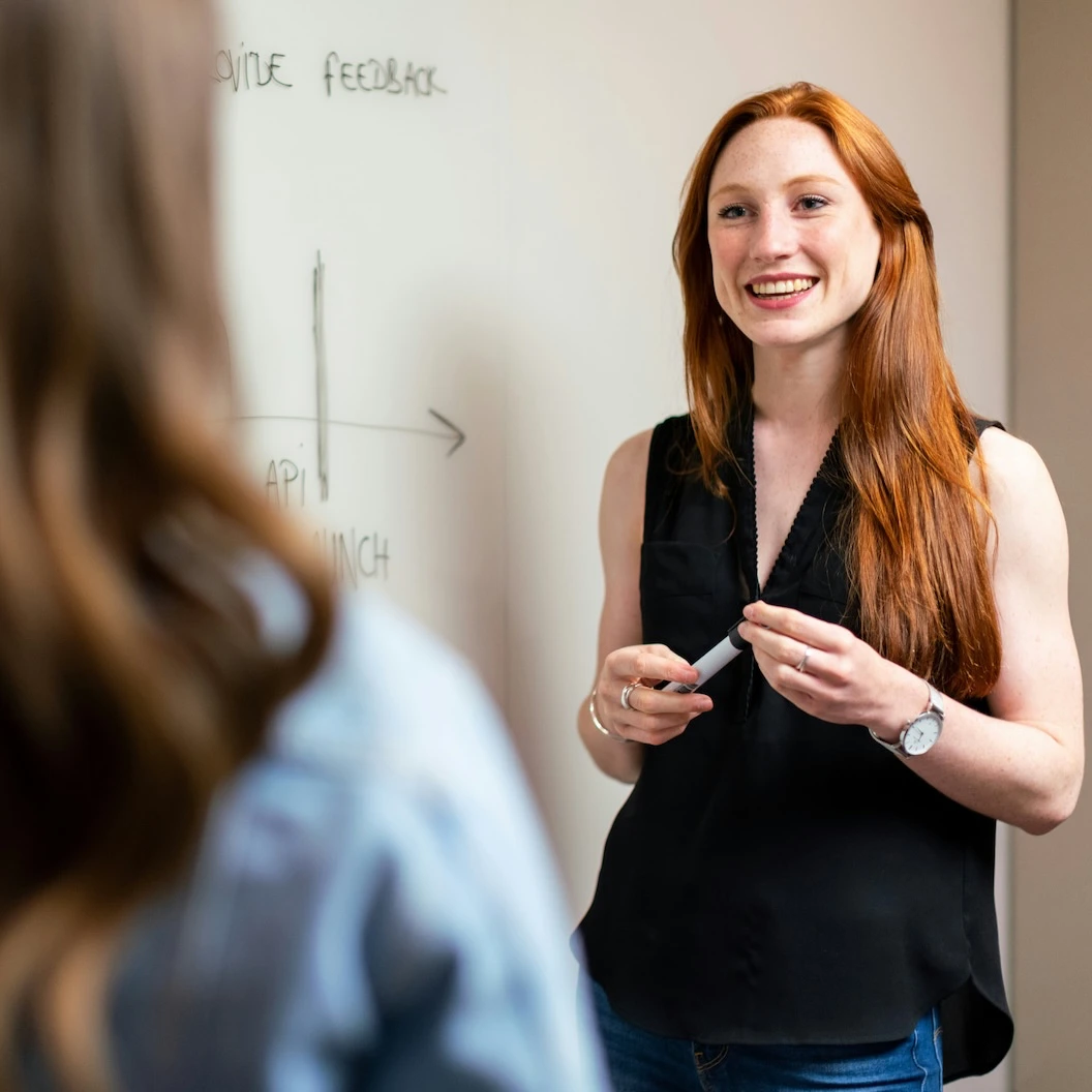 A woman presenting something to another woman