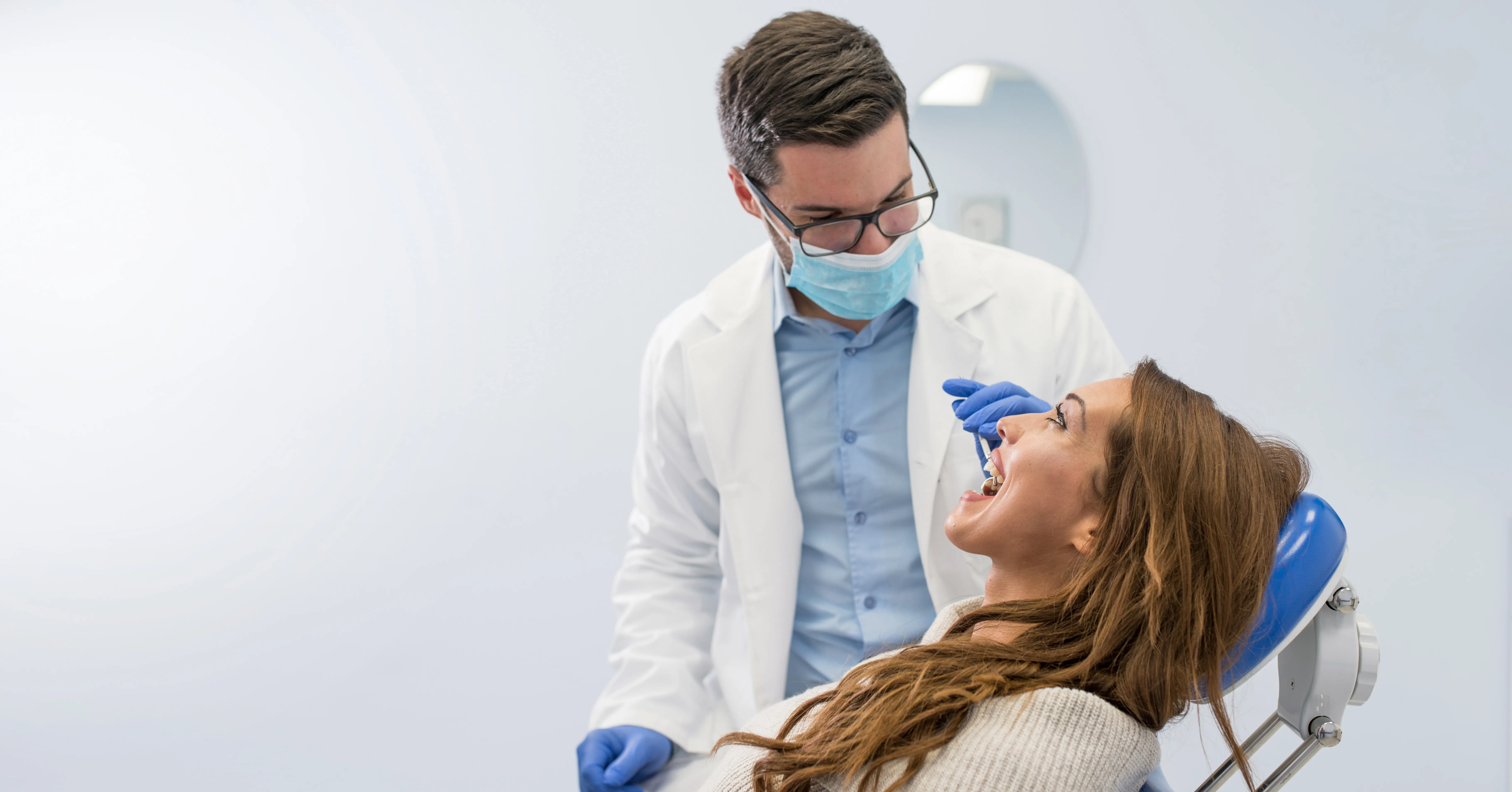 Dentist talking with a smiling patient in the dental chair