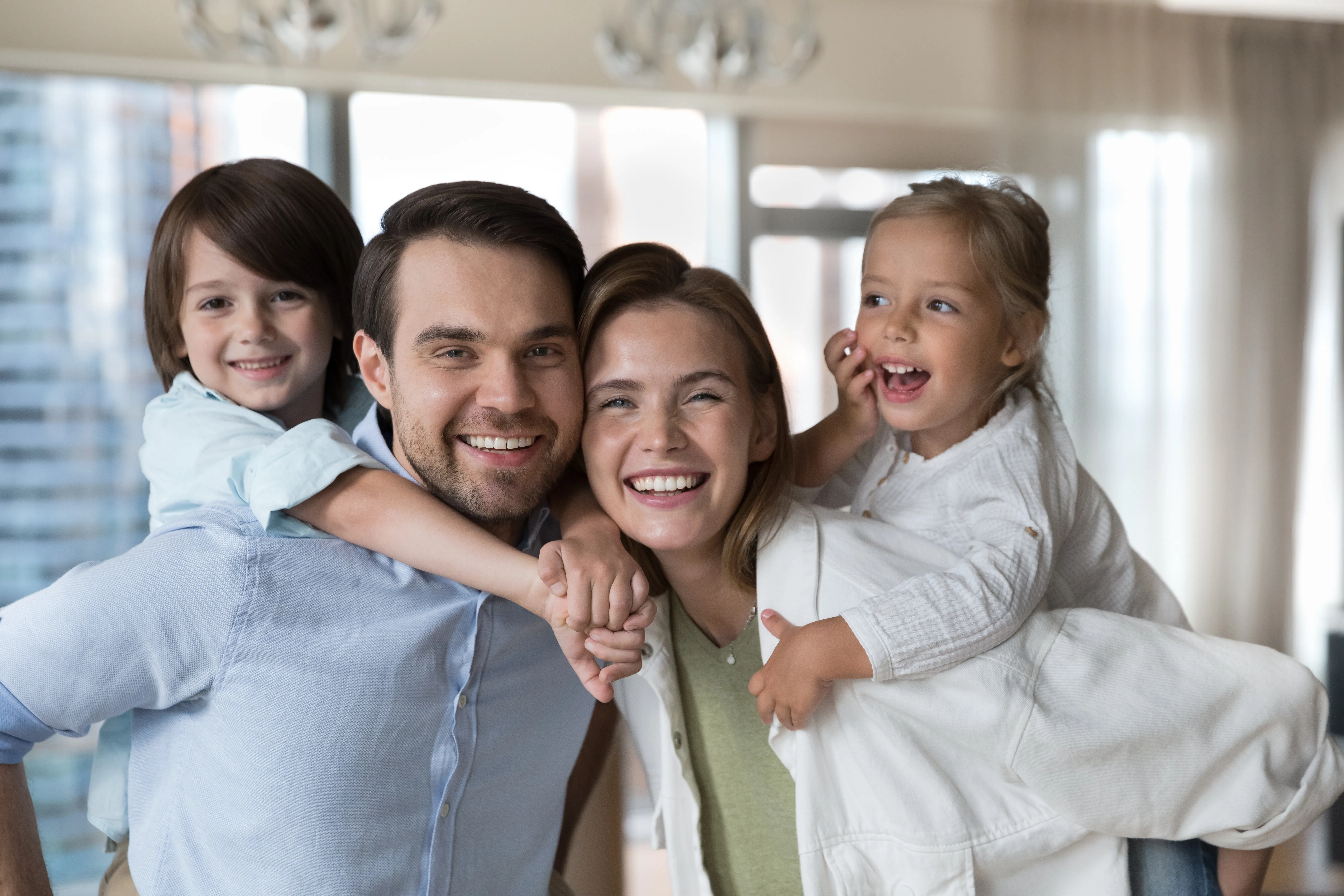 Smiling family of four with two children playing together at home