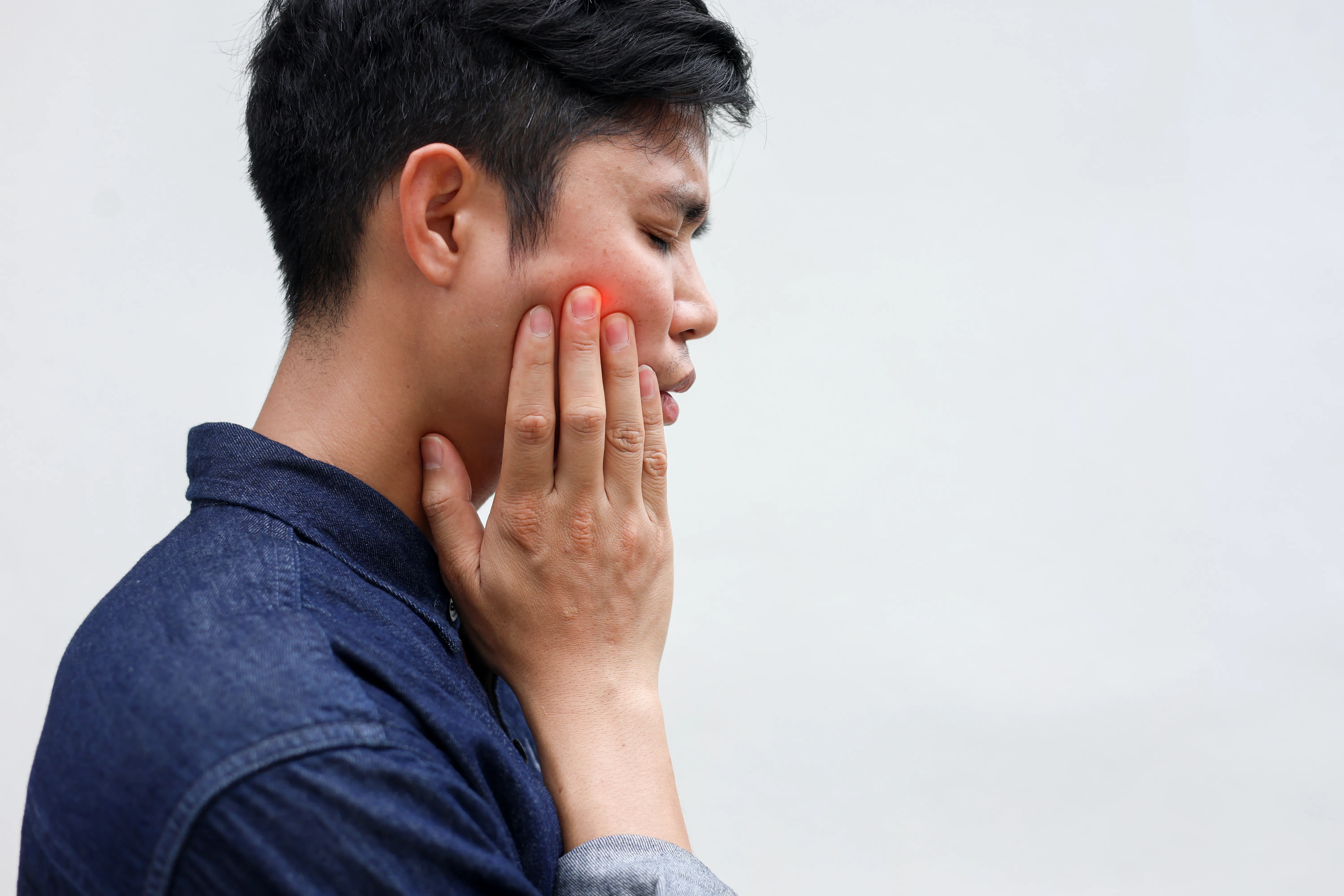 Young man suffering from jaw pain