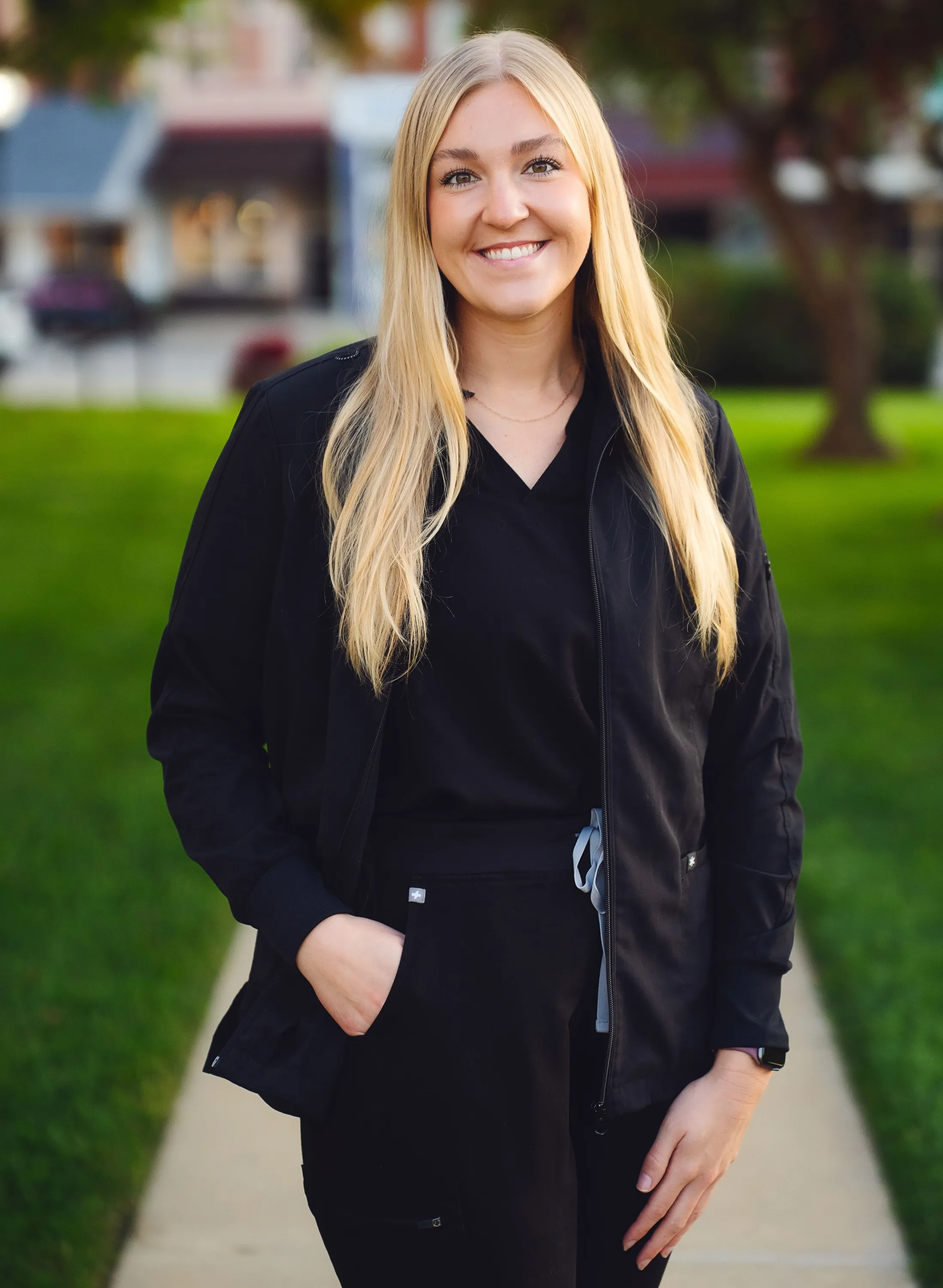 Portrait of Dr. Emma Ahrenholtz in dark scrubs standing outdoors in Harlan