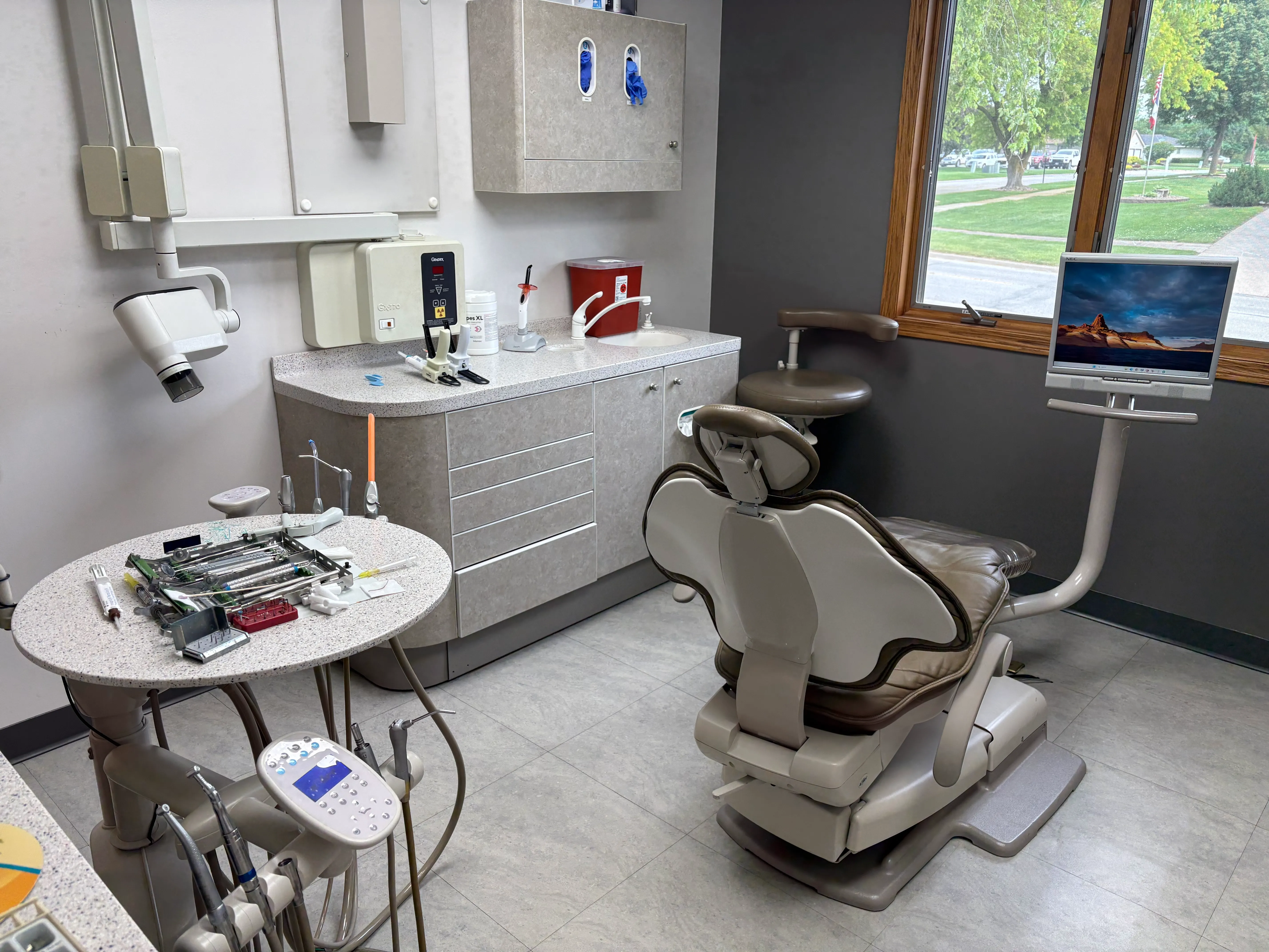 Treatment room at Markham Family Dental with a dental chair, X-ray unit and window