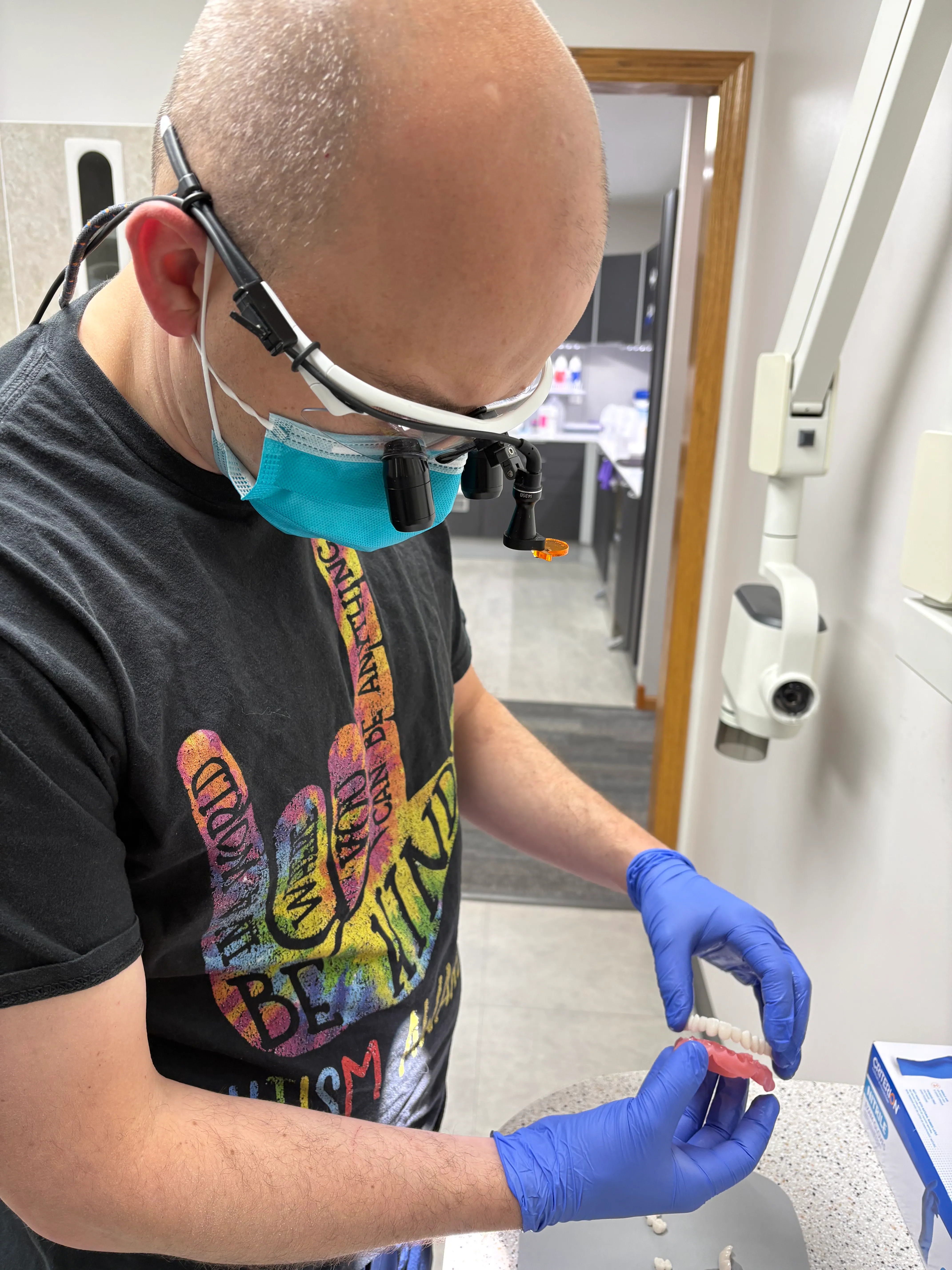 Clinician examining a custom dental restoration on a model